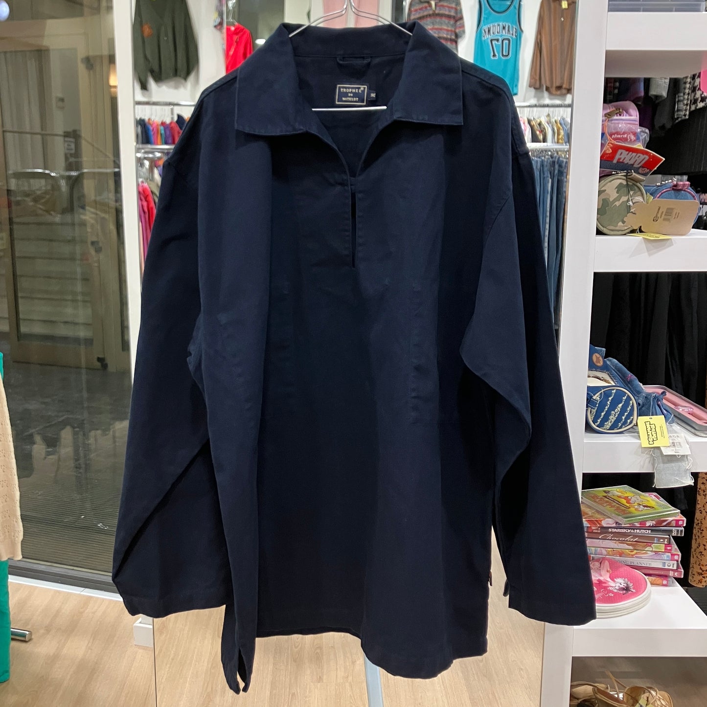 Navy blue shirt on a hanger in a store setting