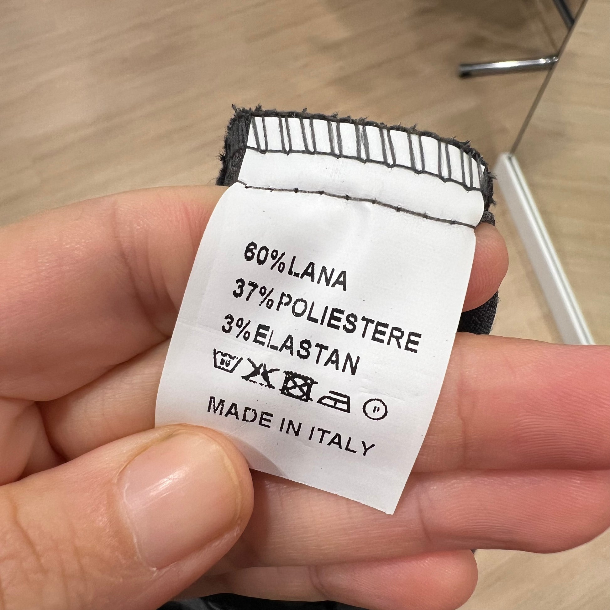 Clothing label with fabric composition details held in a hand