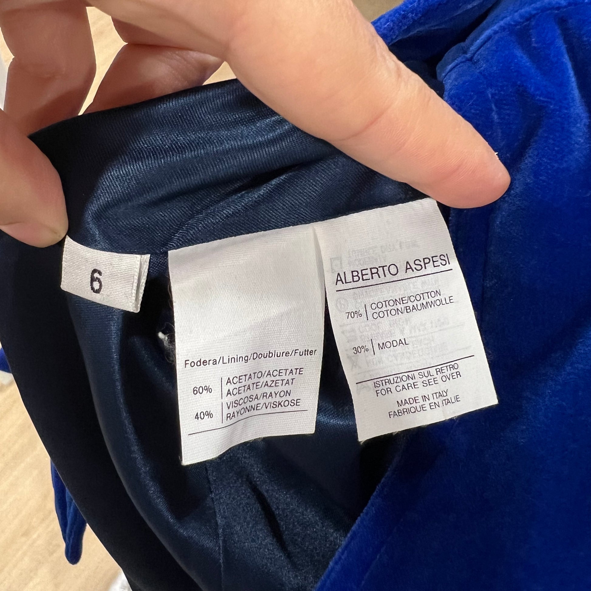 Clothing label with 'Alberto Aspesi' on a blue garment