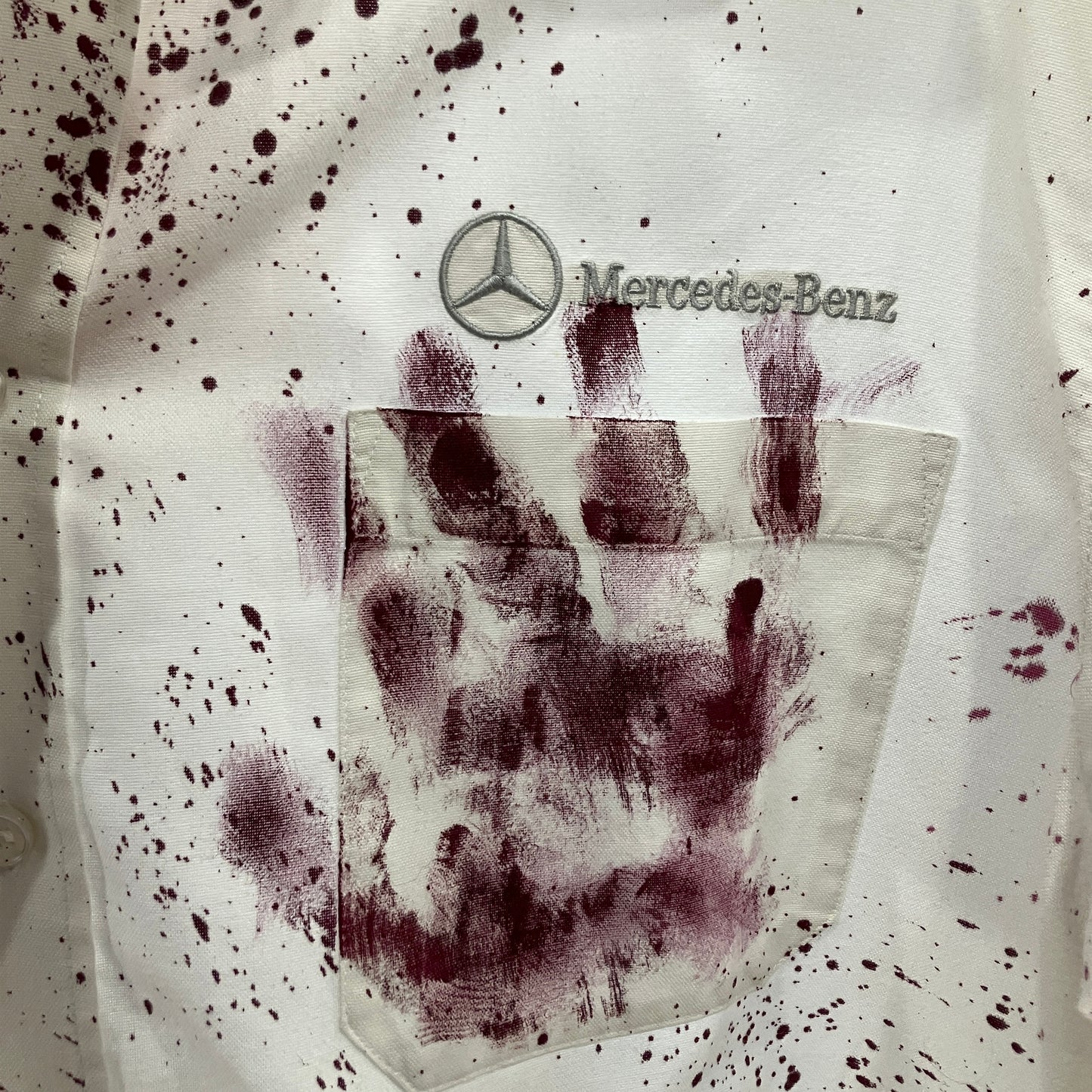 Mercedes-Benz logo on a shirt with handprints and bloodstains