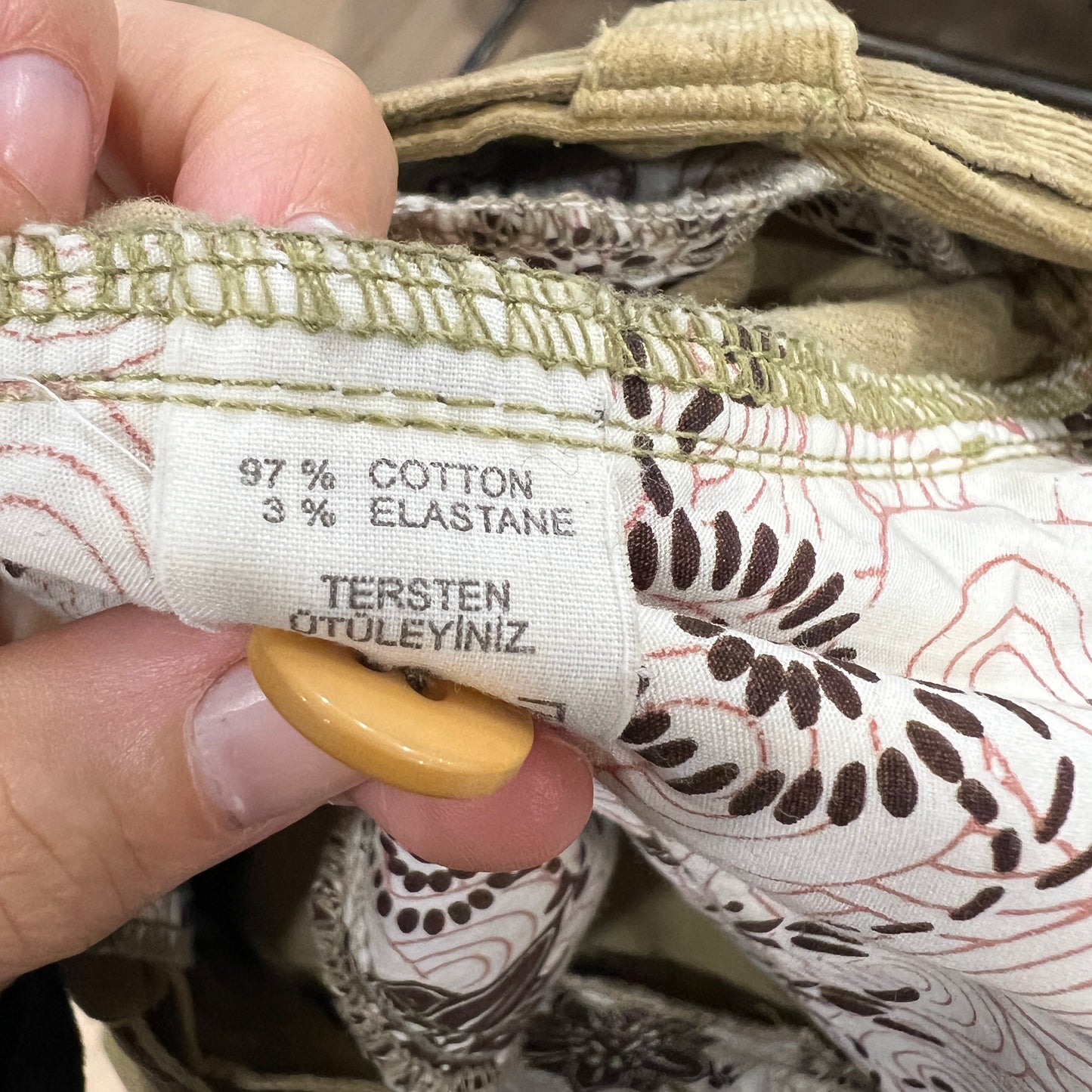 Fabric label with material information held by a hand