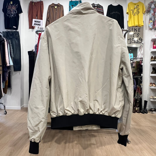 Beige bomber jacket in a clothing store setting
