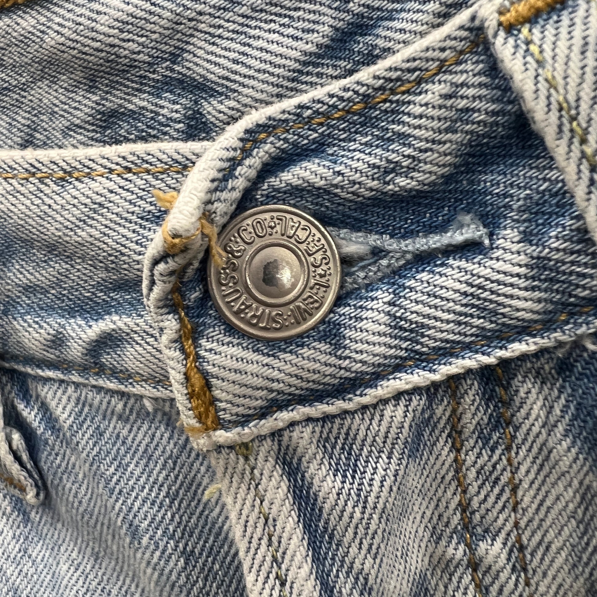 Close-up of a button on a denim jeans with 'Levi's' branding