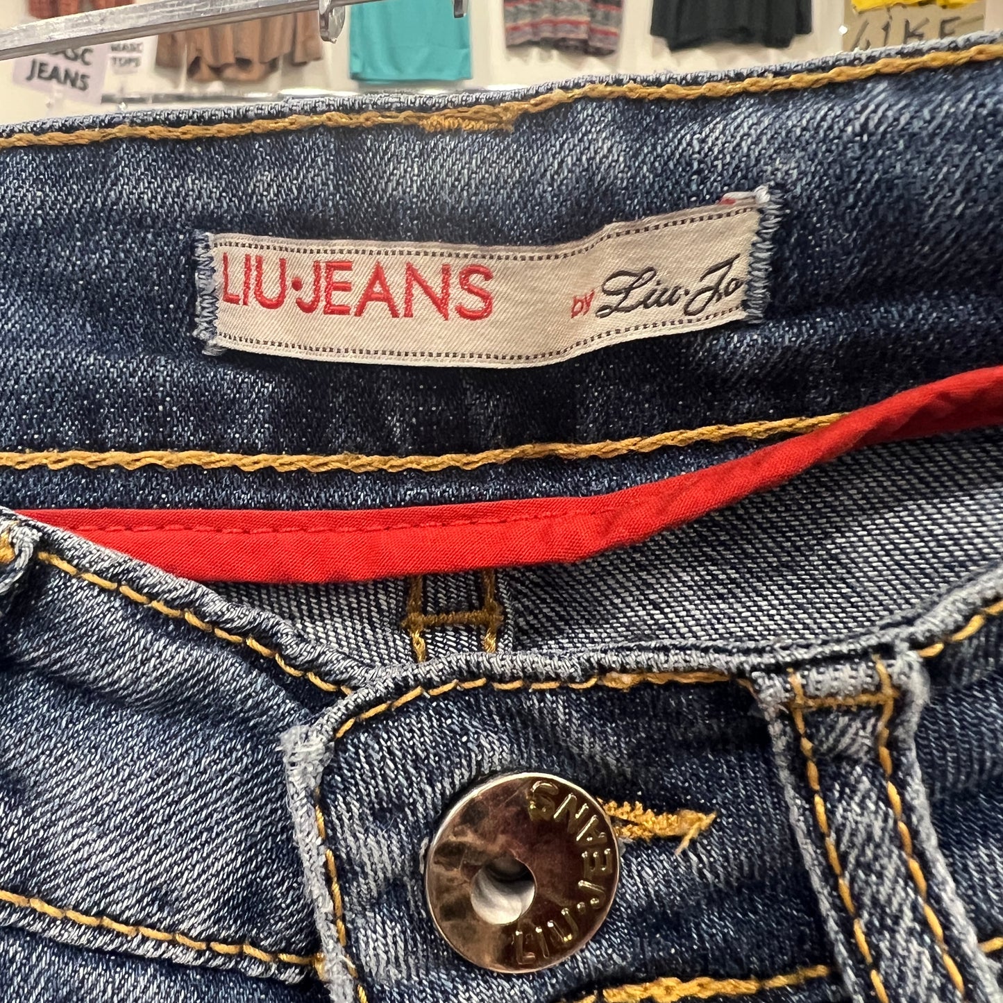 Close-up of Liu Jeans by Liu Jo label on a denim garment with a button