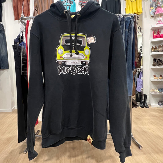 Black hoodie with a graphic design of a yellow car and 'Mr Bean' text, displayed in a store setting