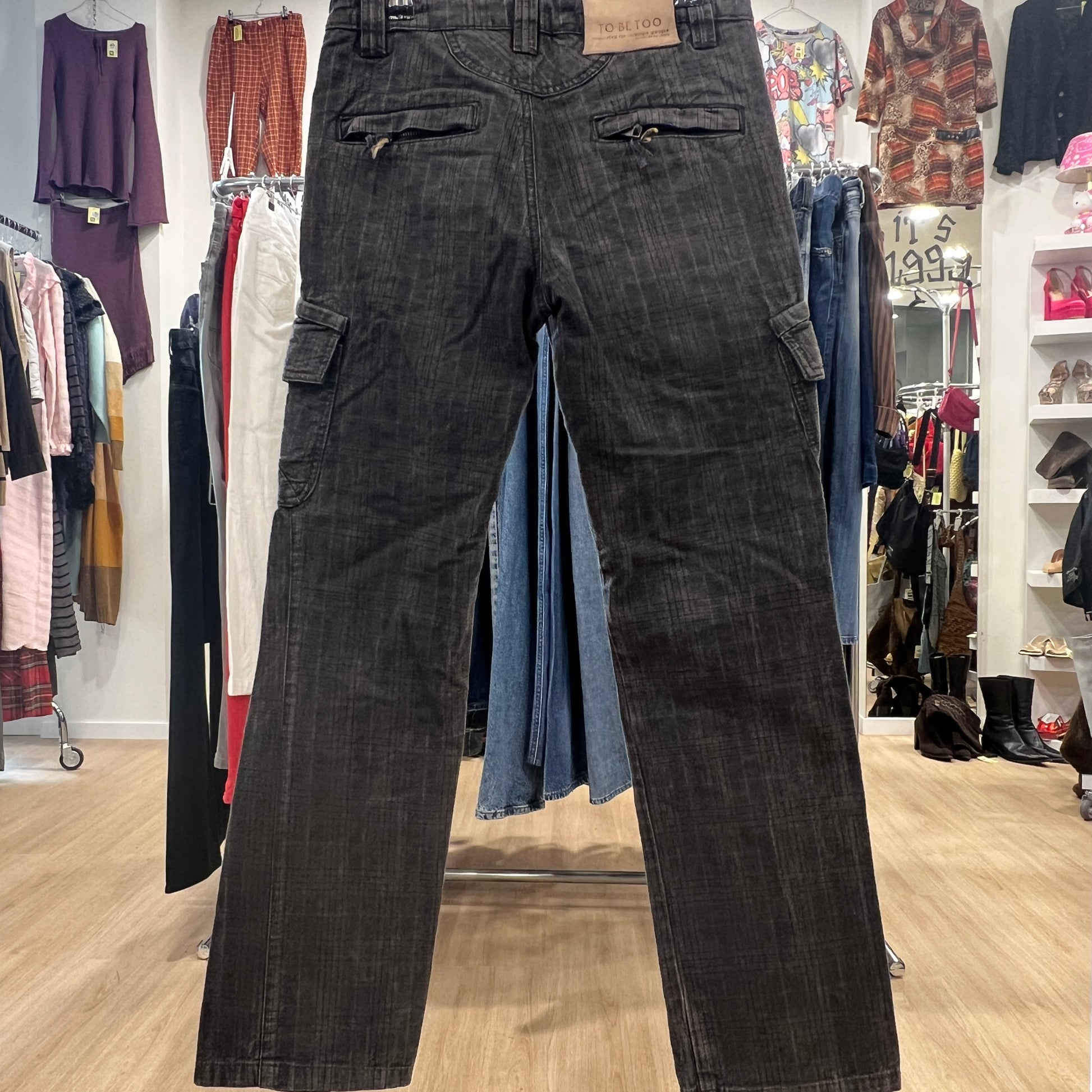 Dark jeans displayed in a clothing store with various garments in the background