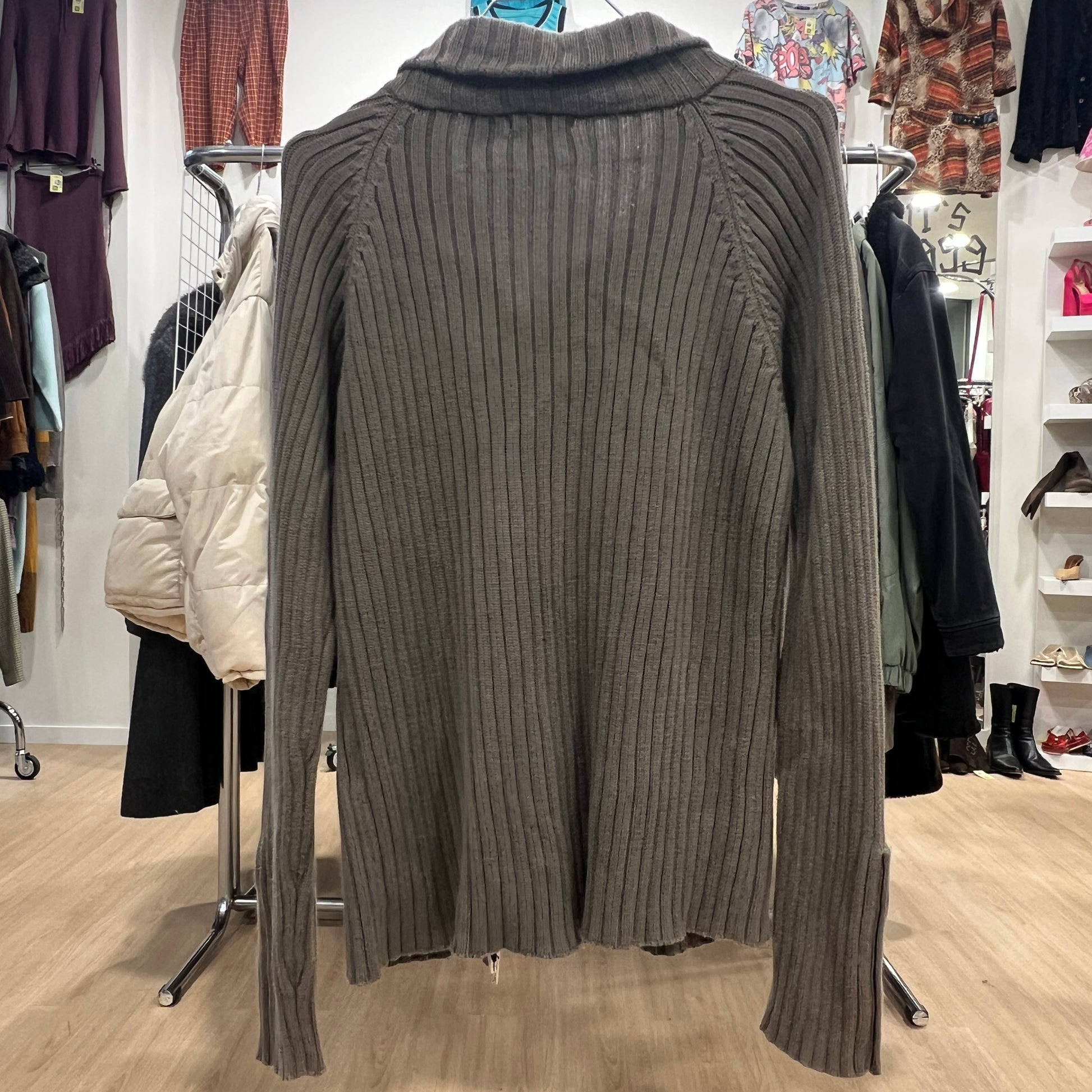 Green ribbed sweater on a rack in a clothing store
