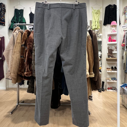 Gray pants hanging in a clothing store with various garments in the background
