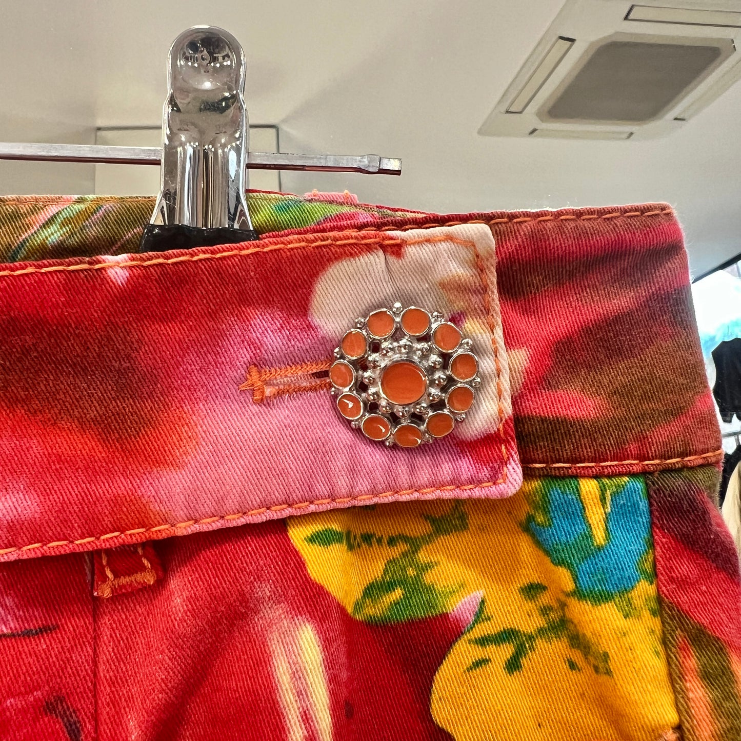 Close-up of a colorful fabric with a decorative button on a hanger