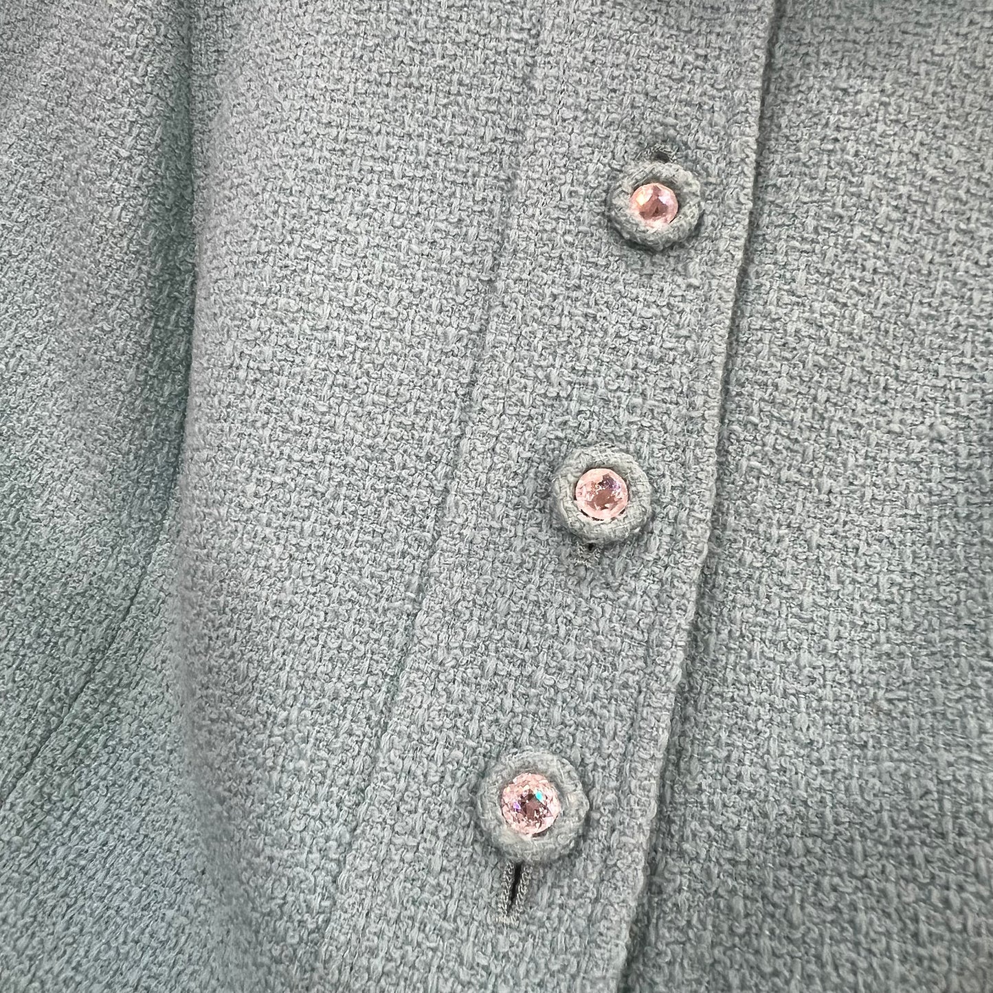 Close-up of a textured gray fabric with buttons on a garment