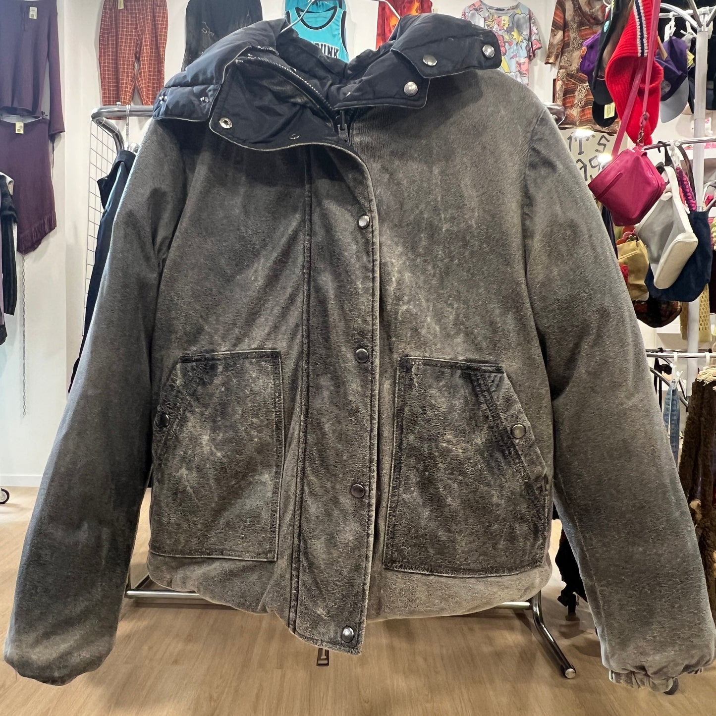 Gray distressed jacket on a rack in a store setting