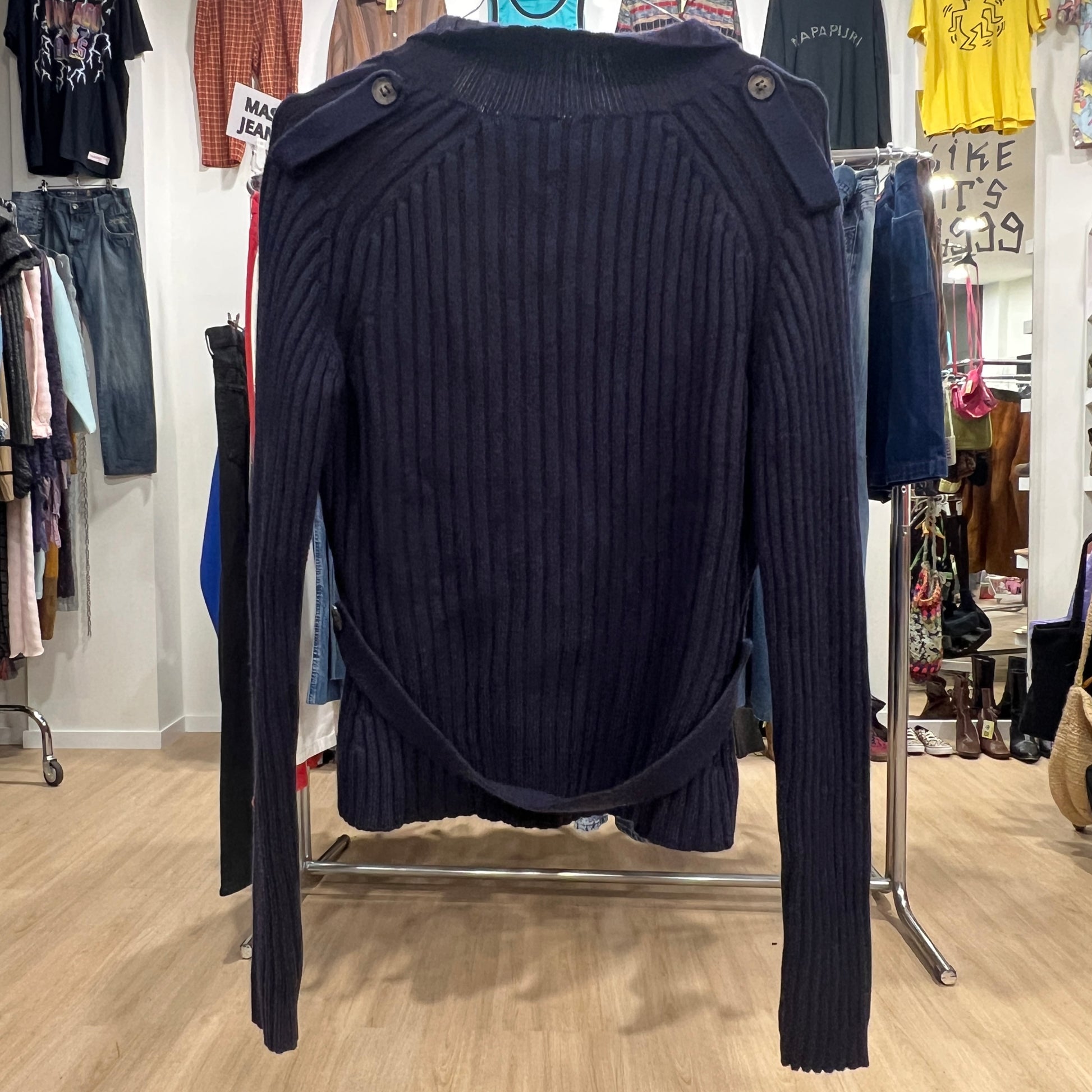 Navy blue ribbed sweater on a rack in a clothing store