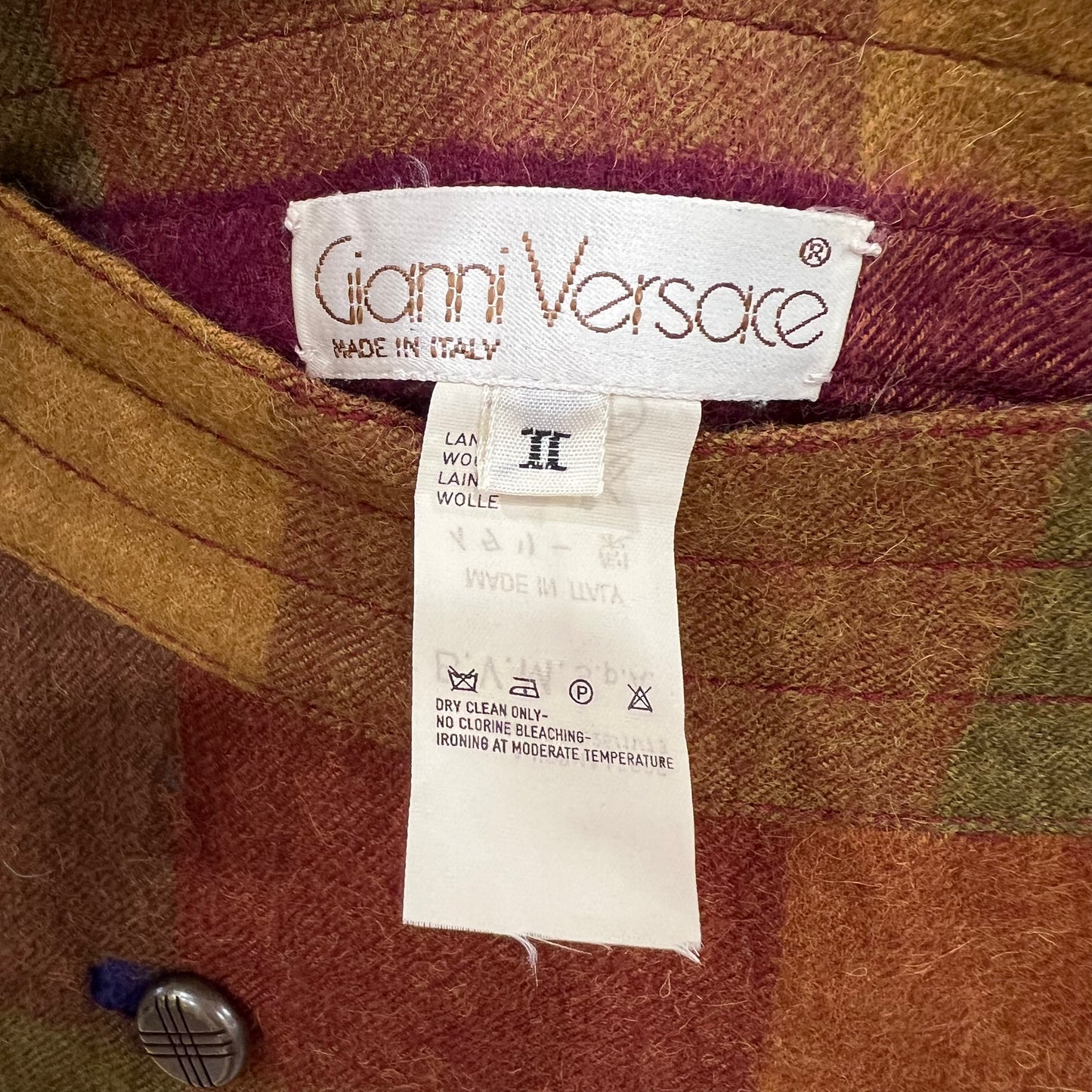 Gianni Versace label on a textured fabric background