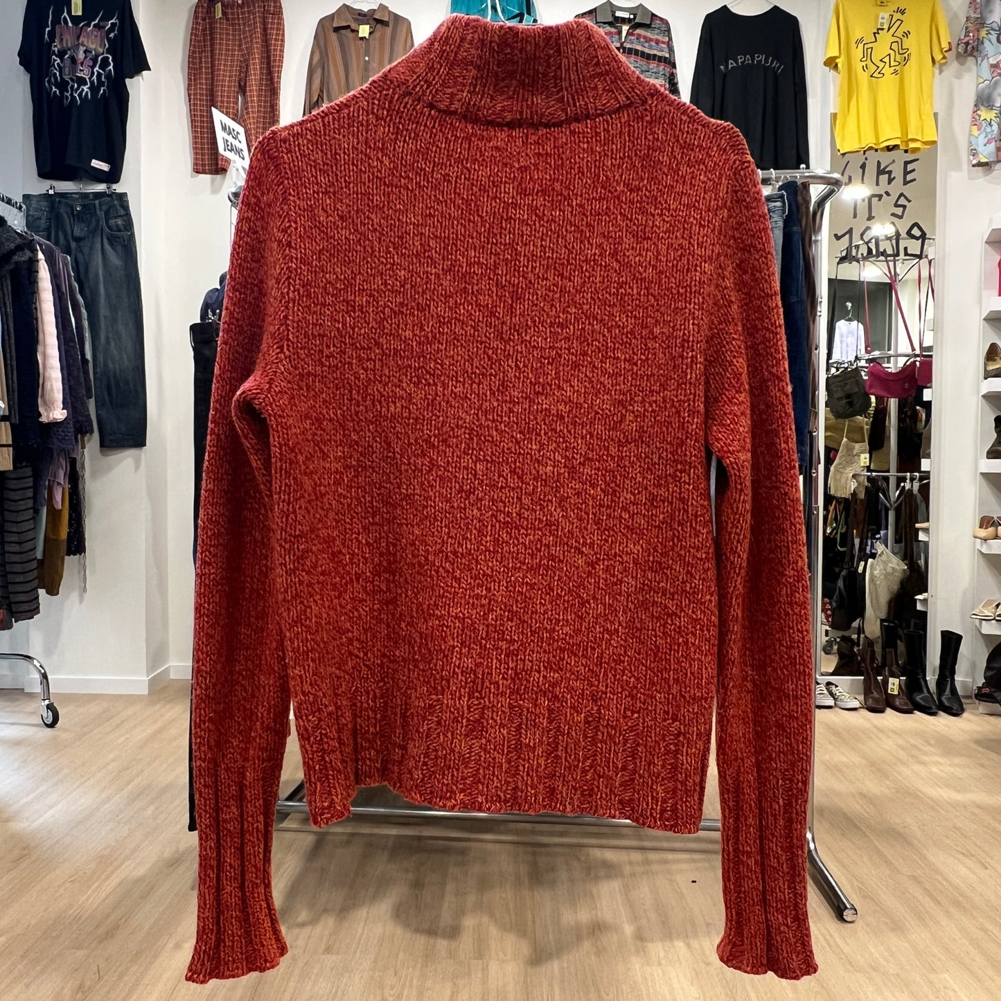 Red turtleneck sweater on a rack in a clothing store