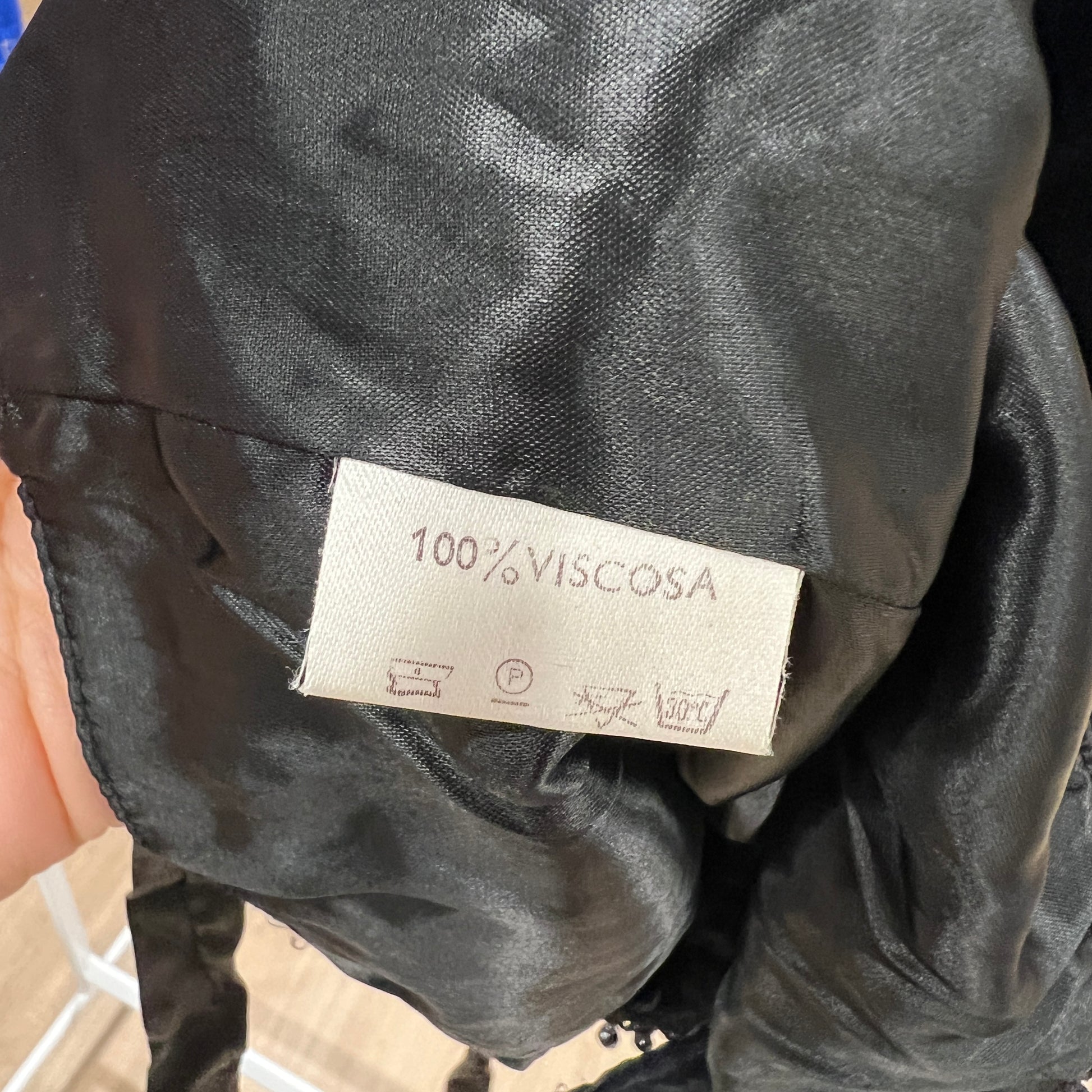 Label on a black fabric with '100% Viscosa' text