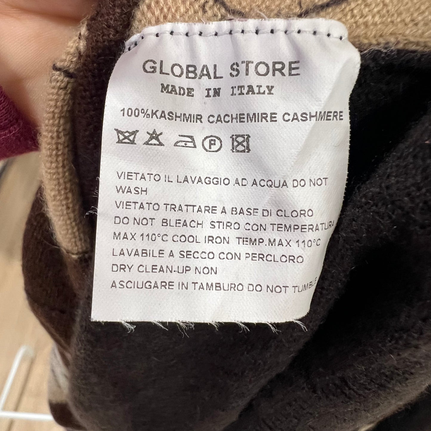 Clothing label on a garment with text and symbols indicating care instructions