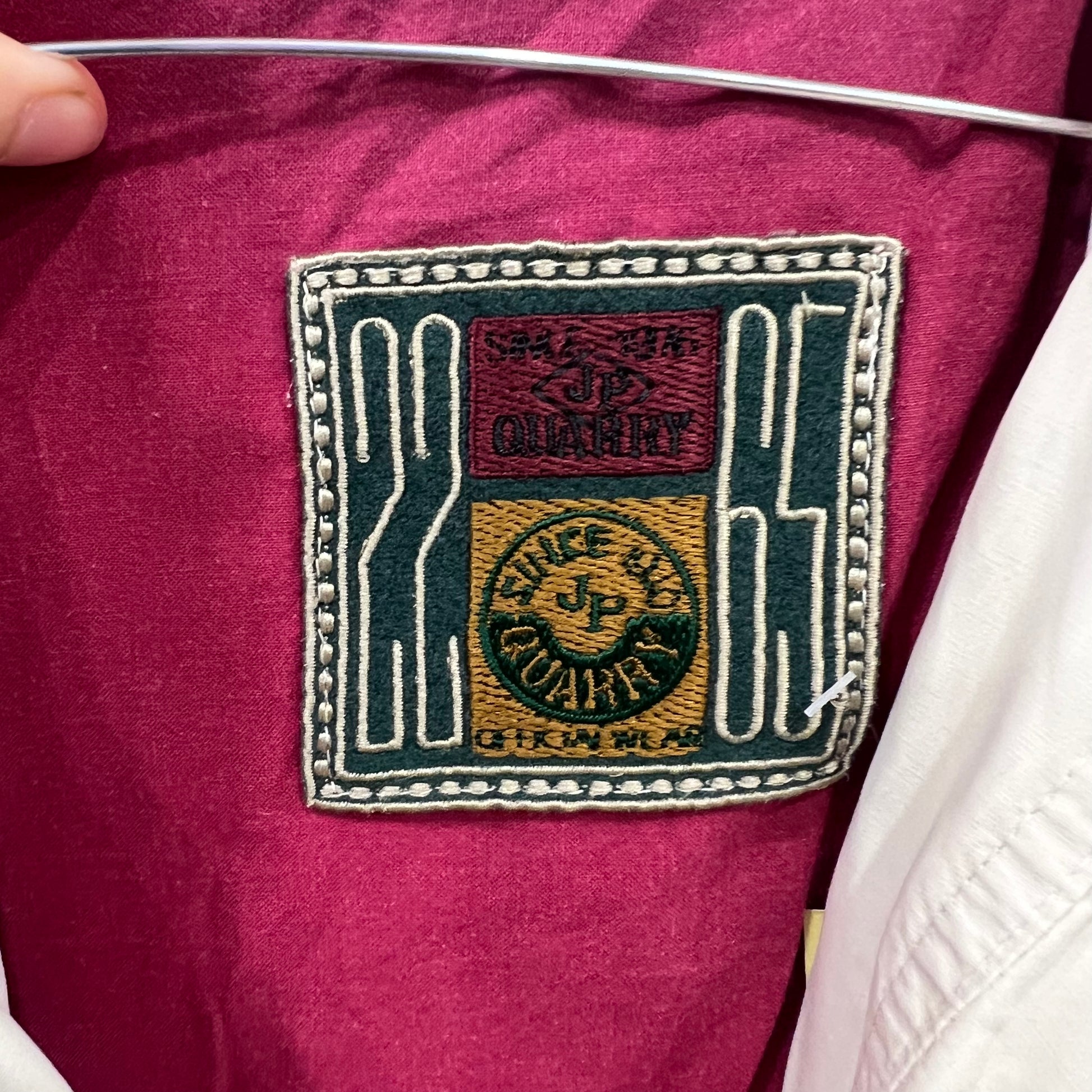Close-up of a brand label on a maroon garment 