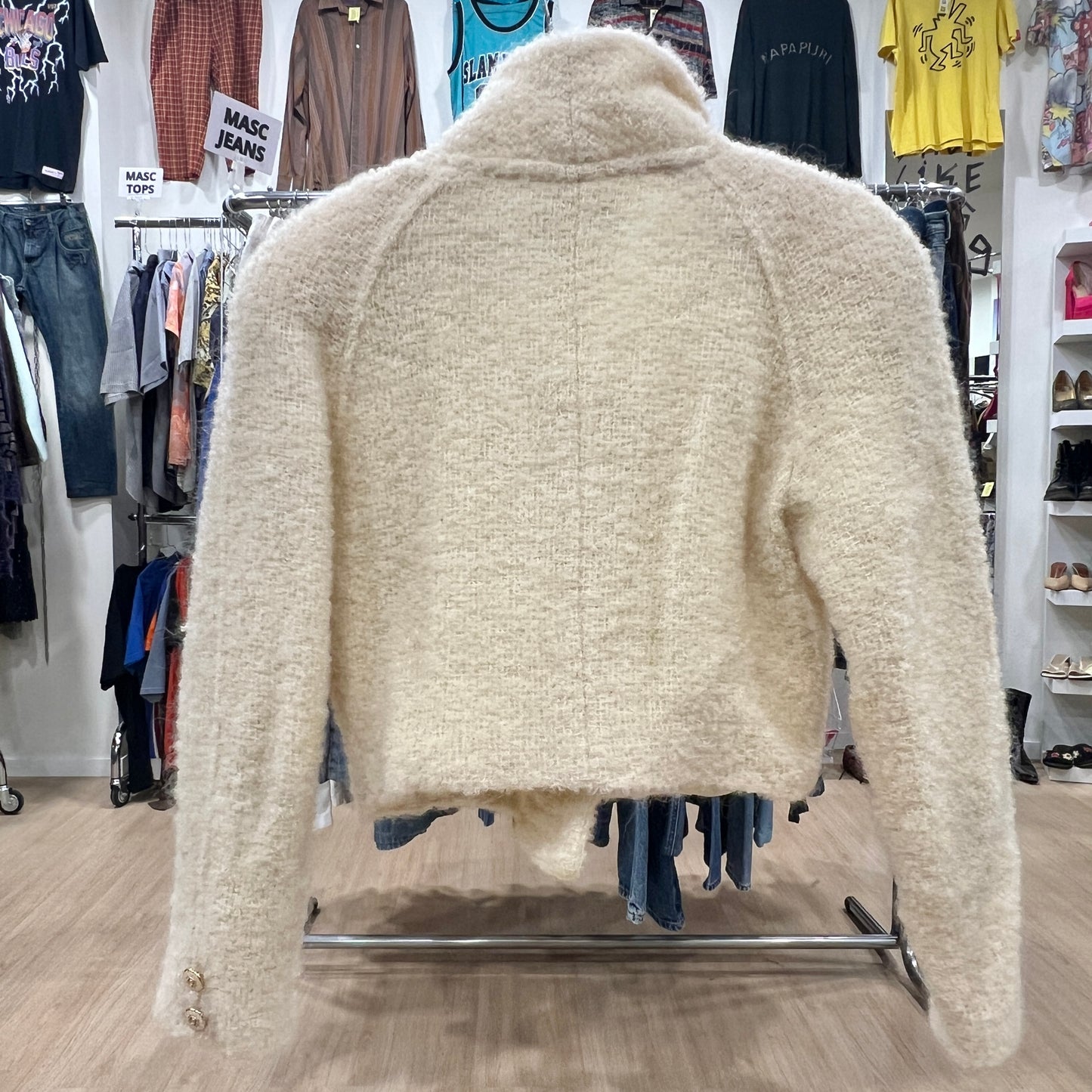 Beige fleece jacket on a rack in a clothing store
