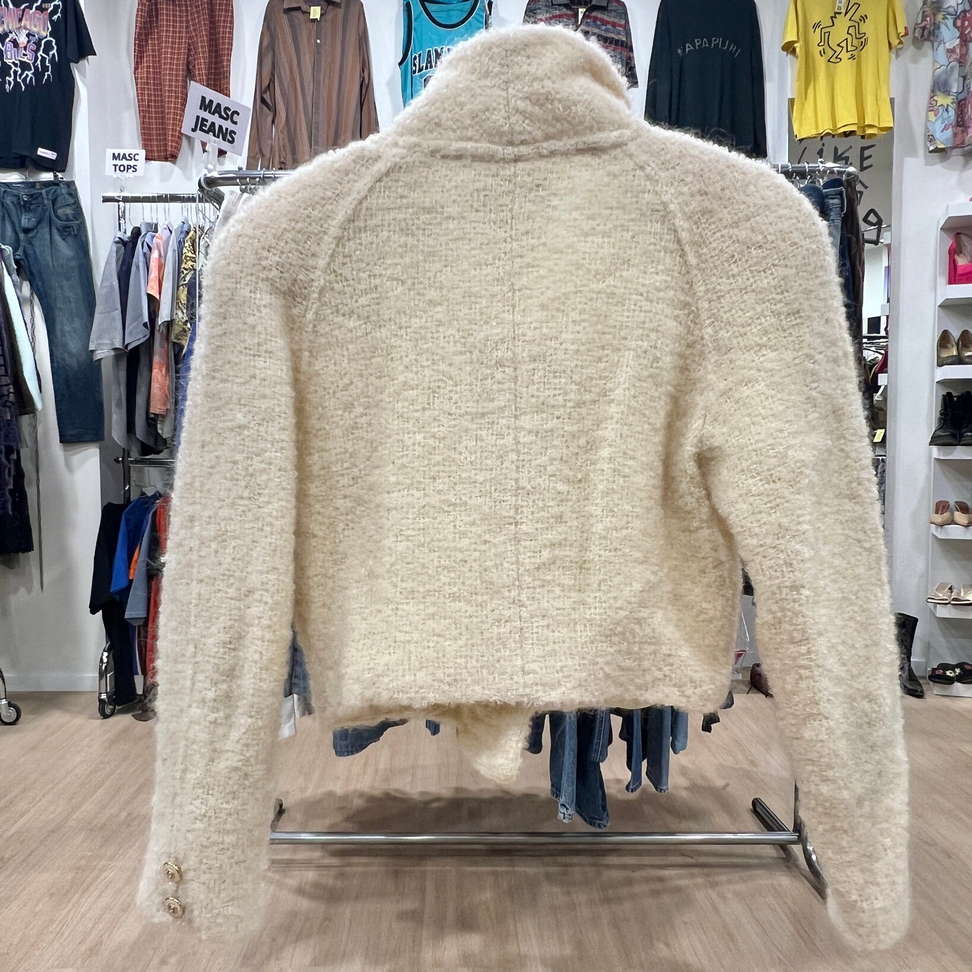 Beige fleece jacket on a rack in a clothing store