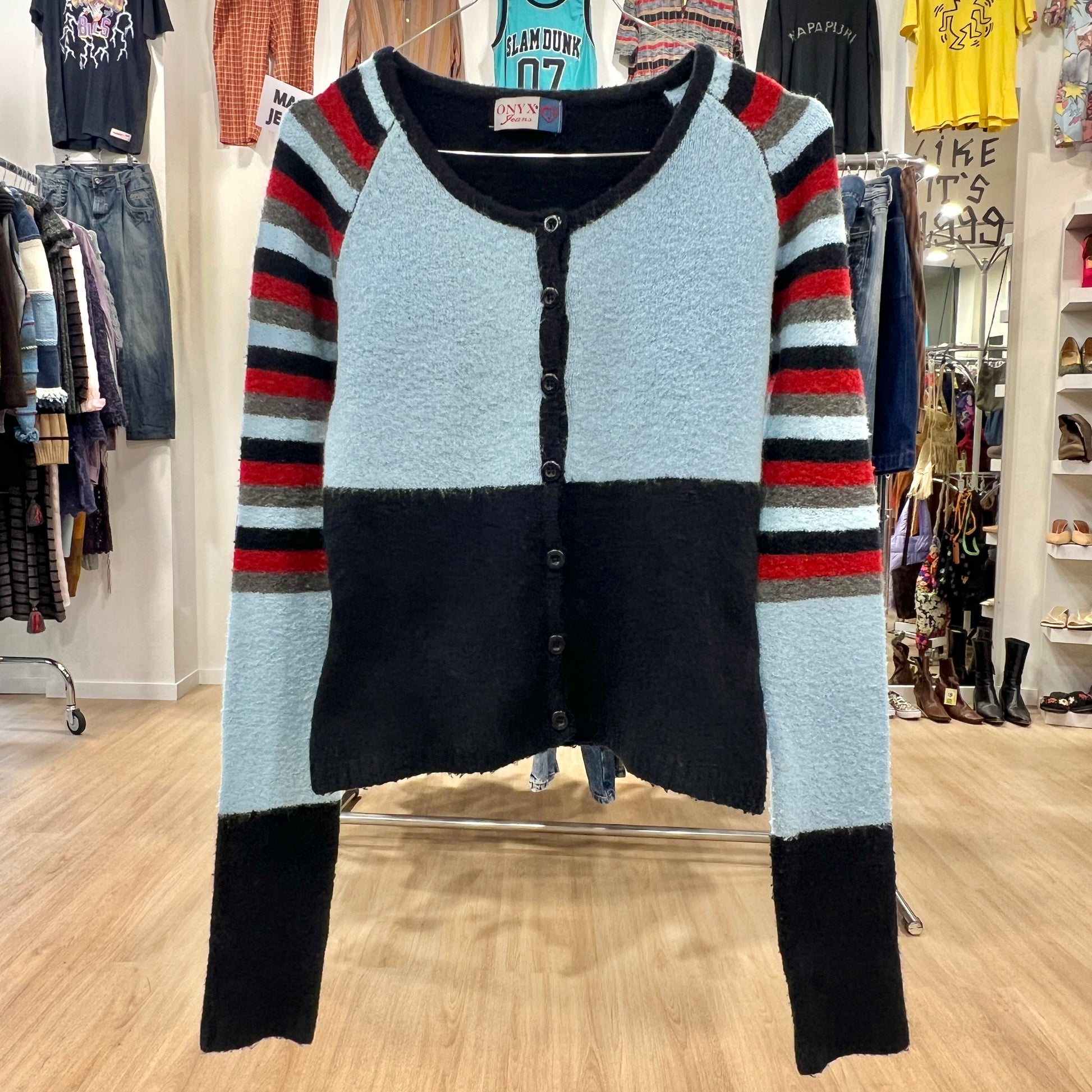 Color-blocked cardigan with striped sleeves in a store setting