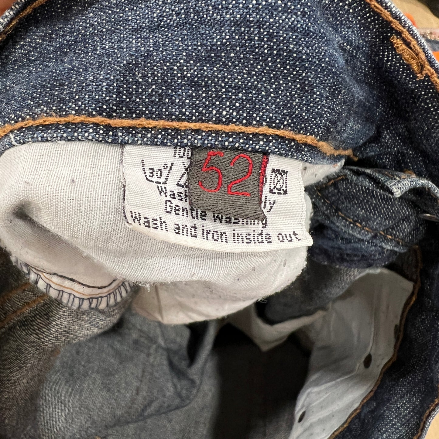 Close-up of a denim garment with a label showing washing instructions