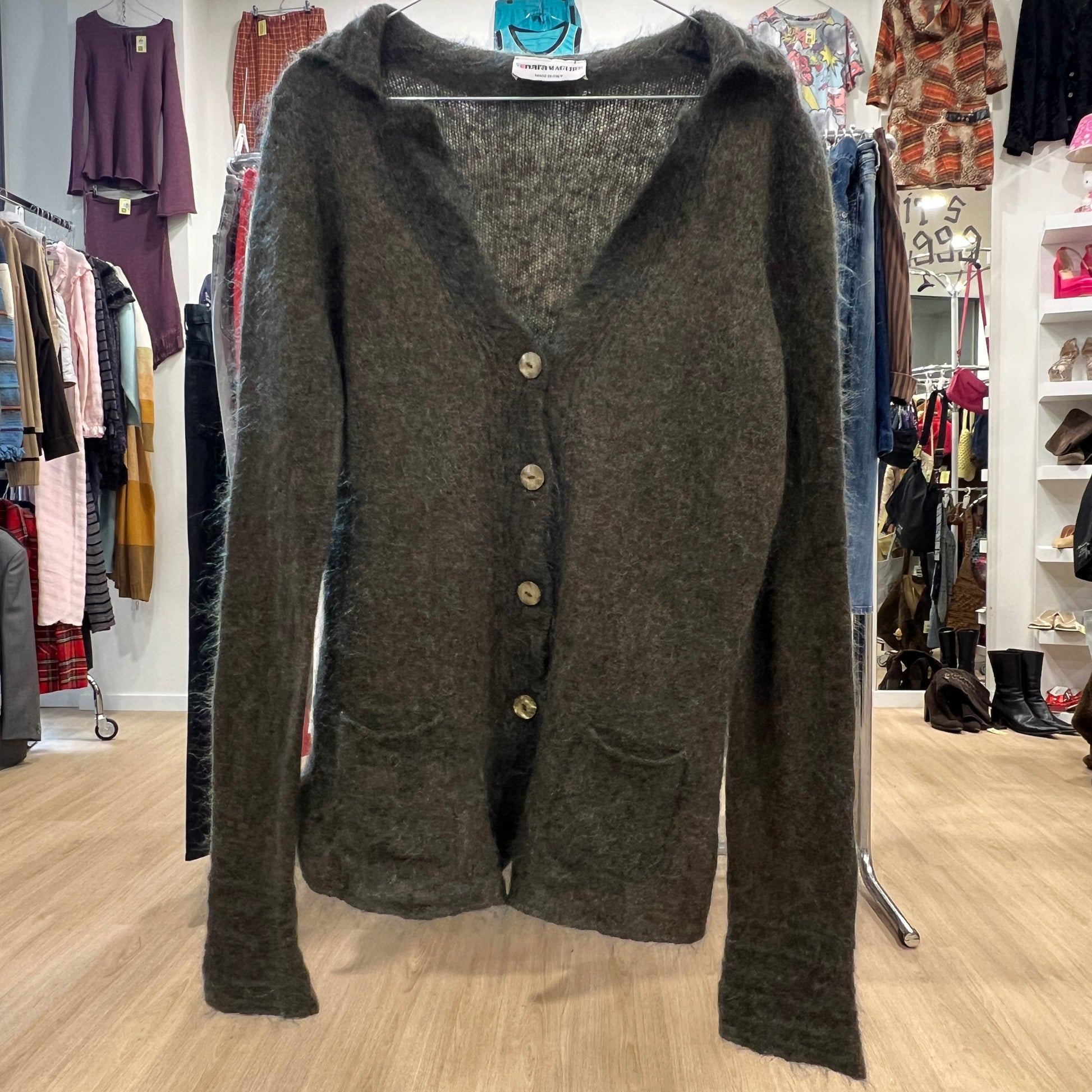 Dark gray cardigan on a hanger in a clothing store