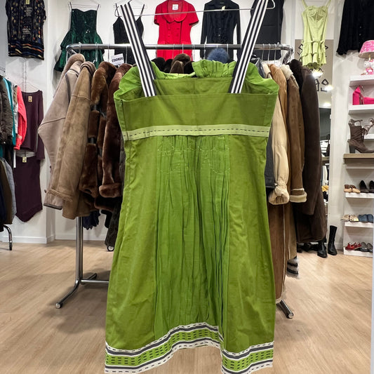 Green dress with black and white stripes hanging on a rack in a store