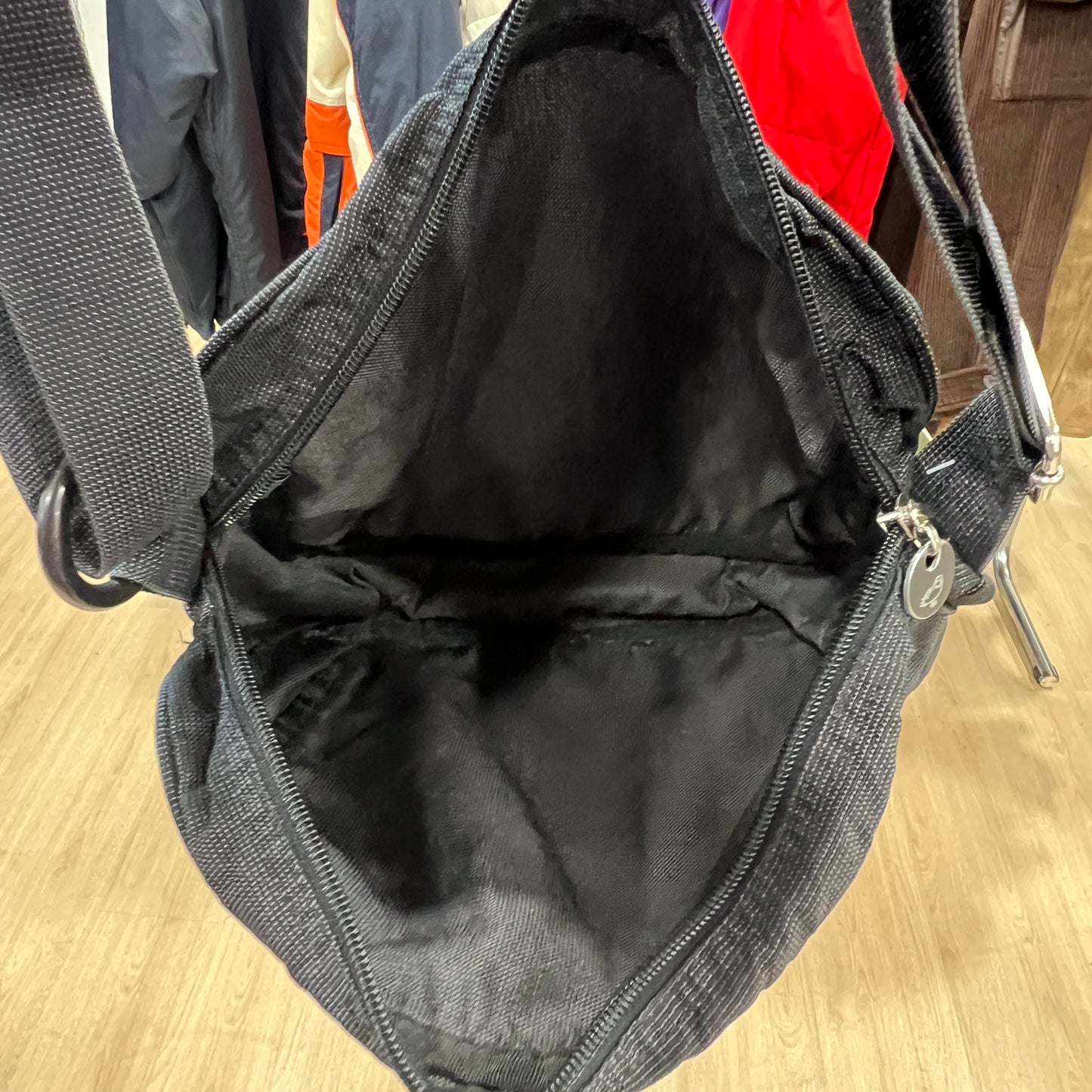 Black bag with a zipper on a wooden floor