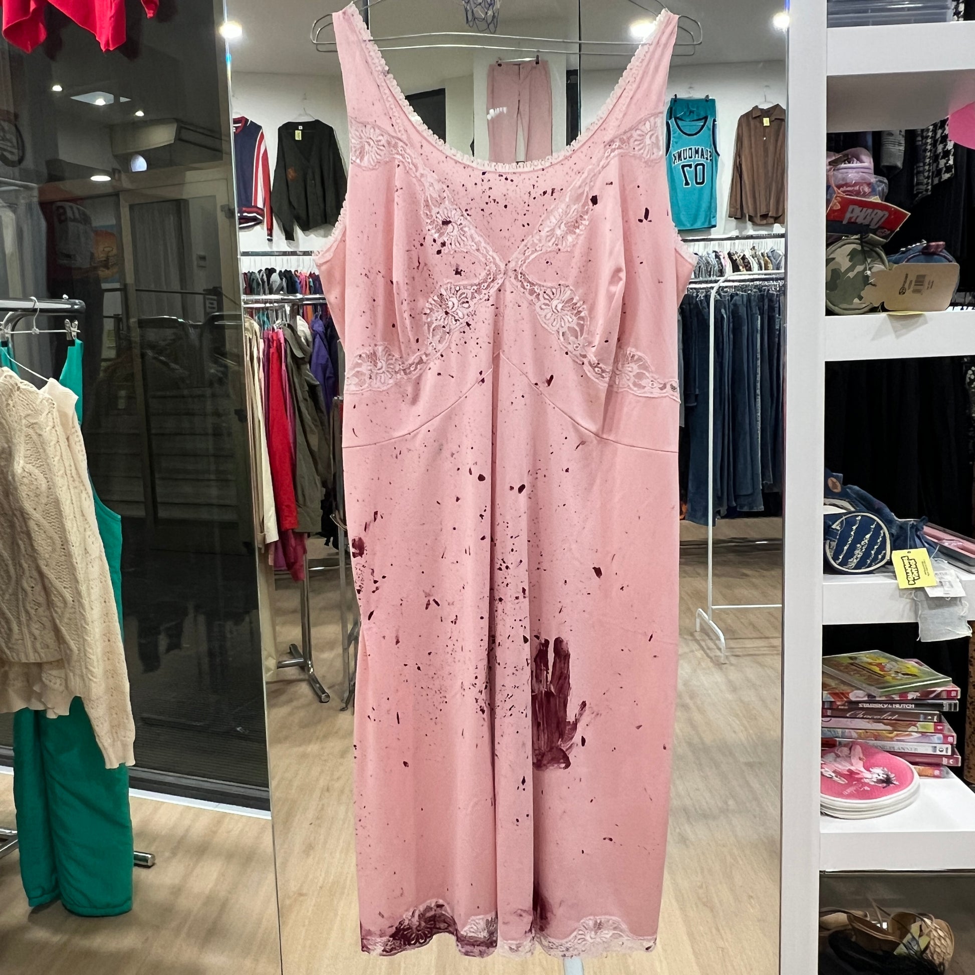 Pink dress with red stains in a store setting