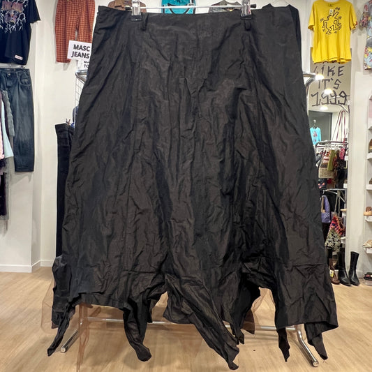 Black skirt hanging on a rack in a store setting with various clothing items in the background