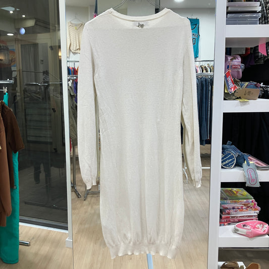 White long-sleeve dress hanging in a store with shelves and clothing in the background