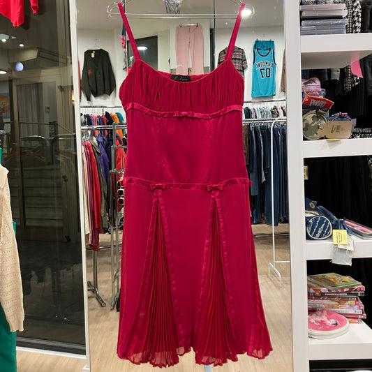 Red dress hanging in a store with various clothing items in the background