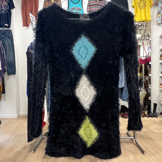 Black textured dress with geometric pattern in a store setting