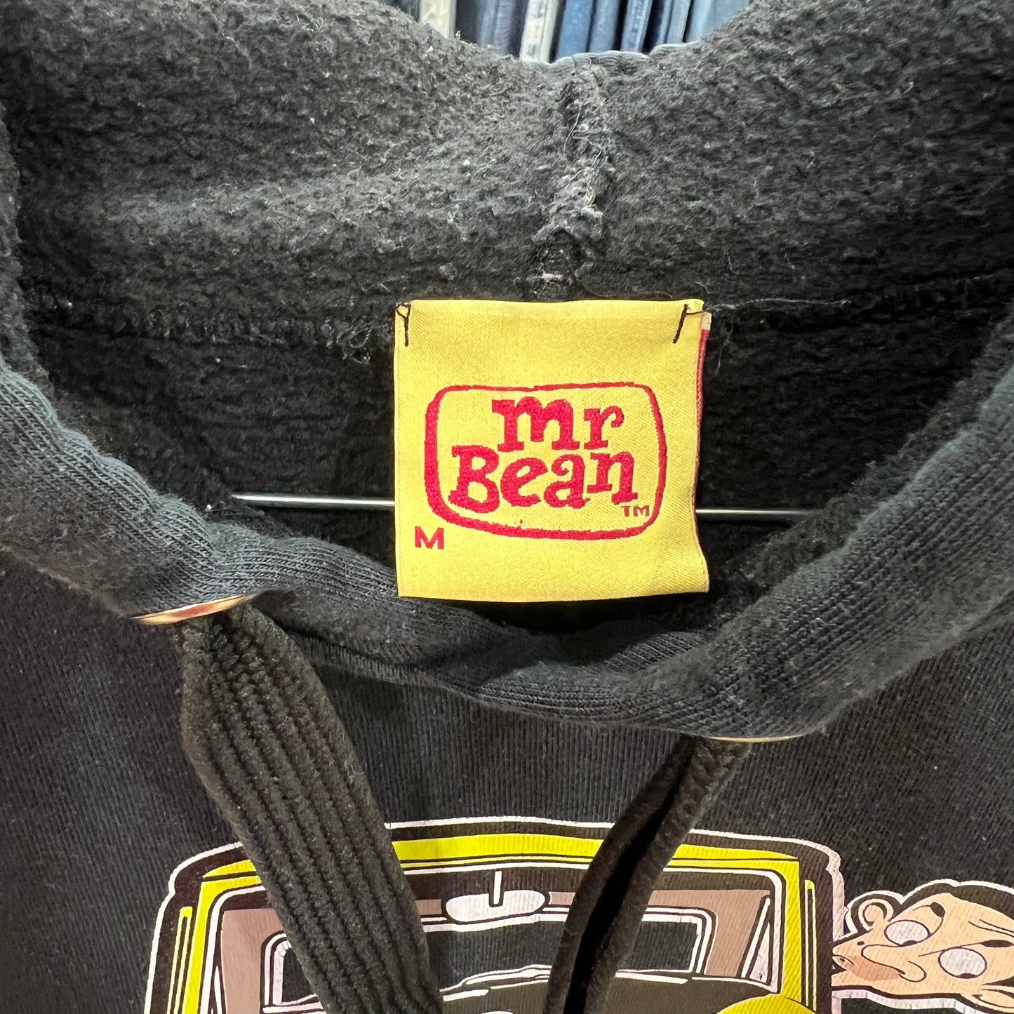 Black hoodie with a yellow 'Mr. Bean' label on a gray background
