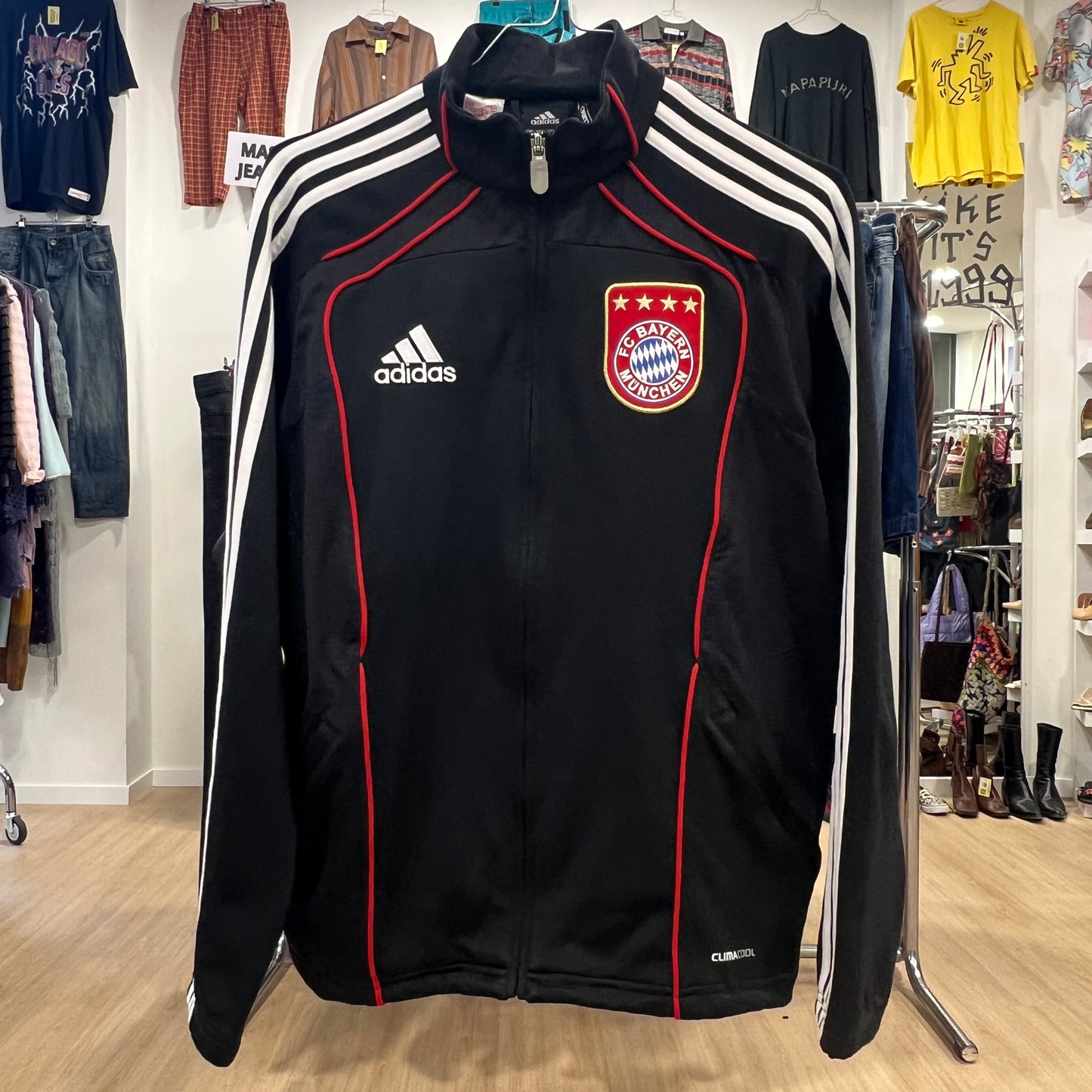 Black Adidas jacket with Bayern Munich logo in a clothing store setting