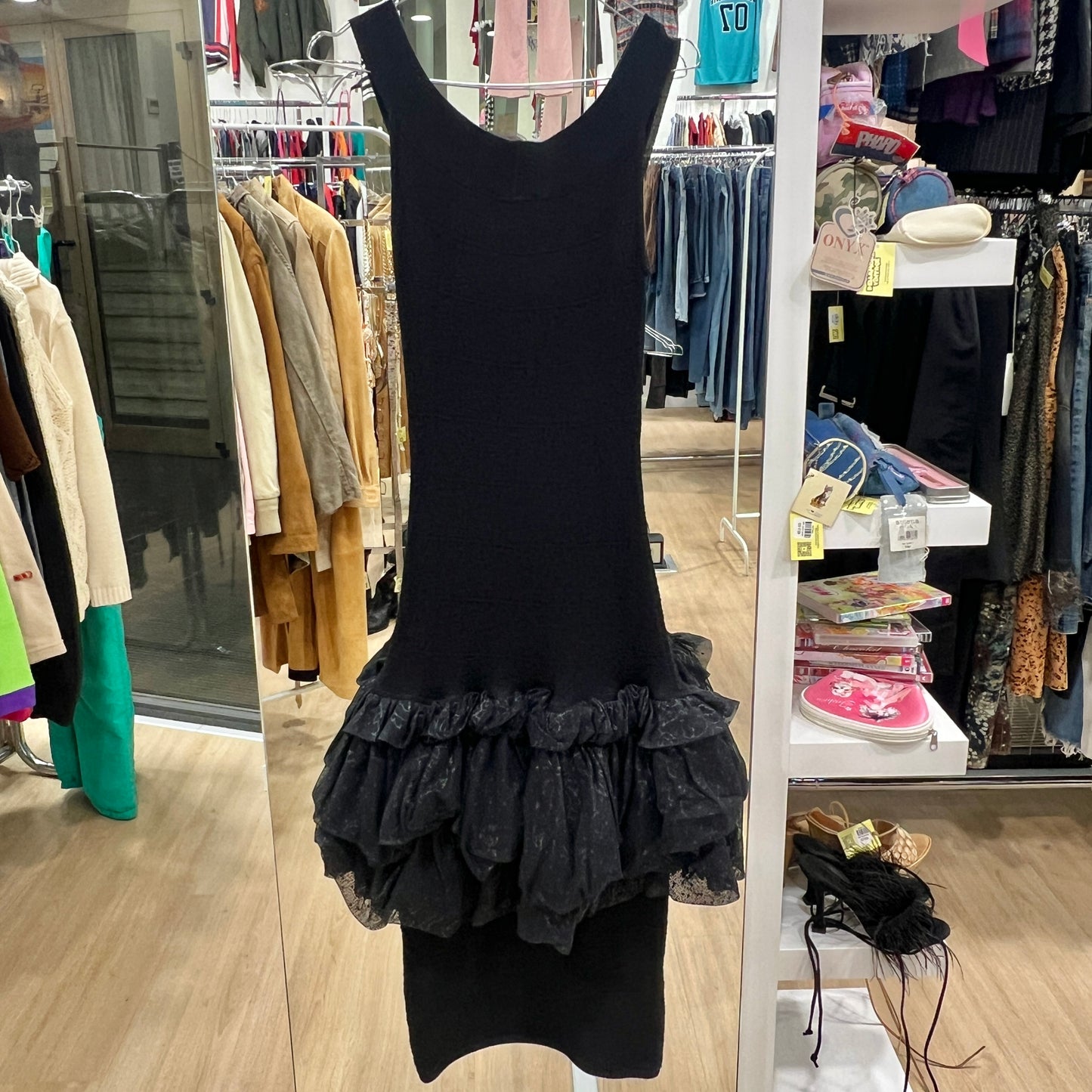 Black dress with ruffled bottom hanging in a store