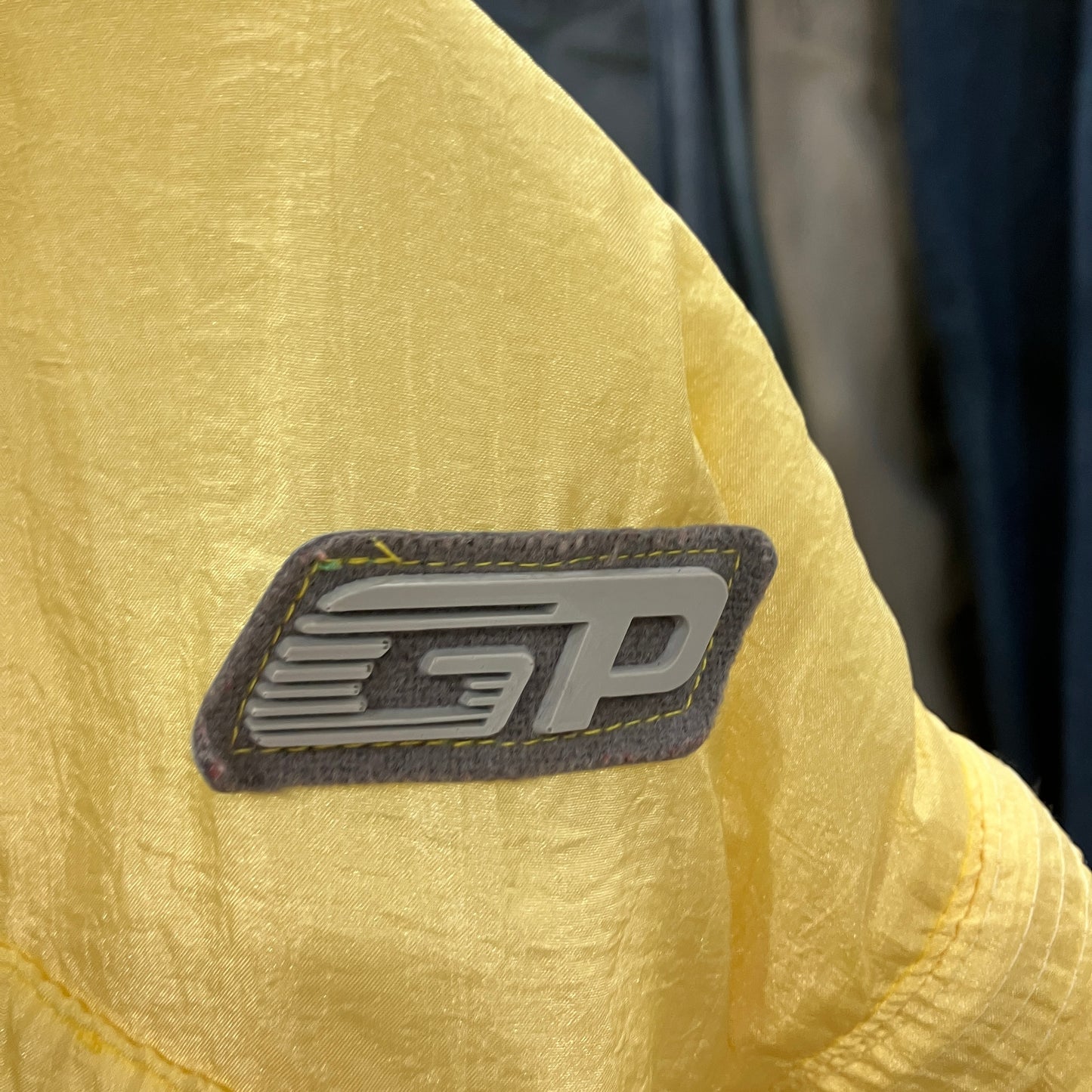 Close-up of a yellow jacket with a logo on the sleeve