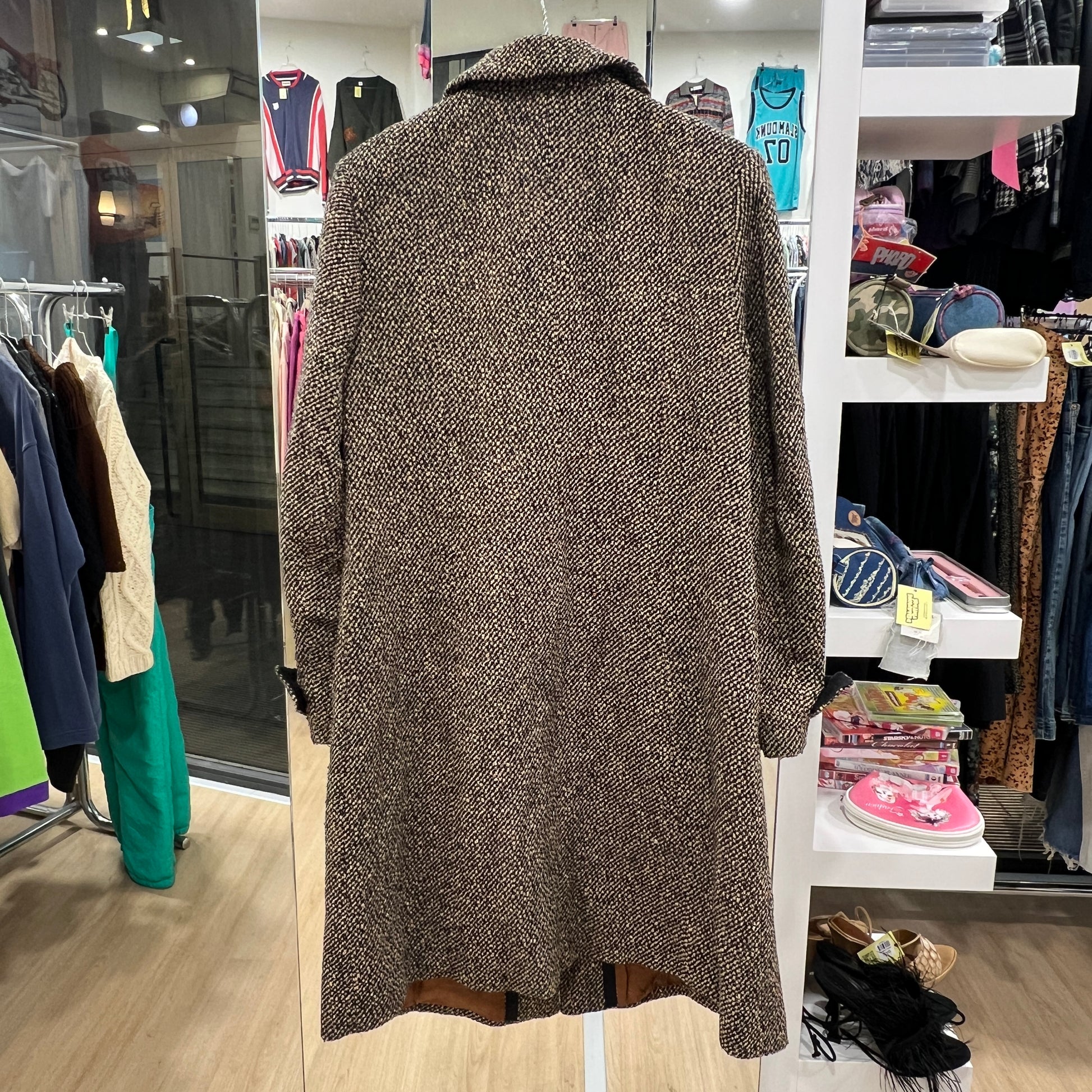 Brown textured coat in a clothing store setting