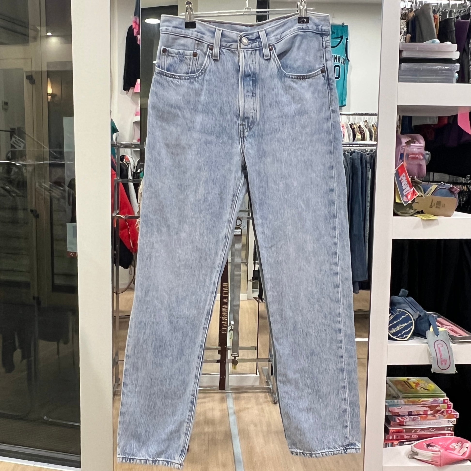 Light blue jeans hanging on a rack in a store setting