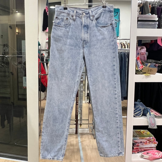 Light blue jeans hanging on a rack in a store setting