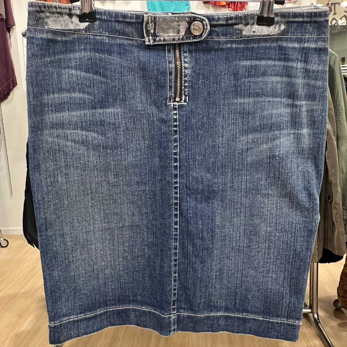 Blue denim skirt on a hanger with a blurred background