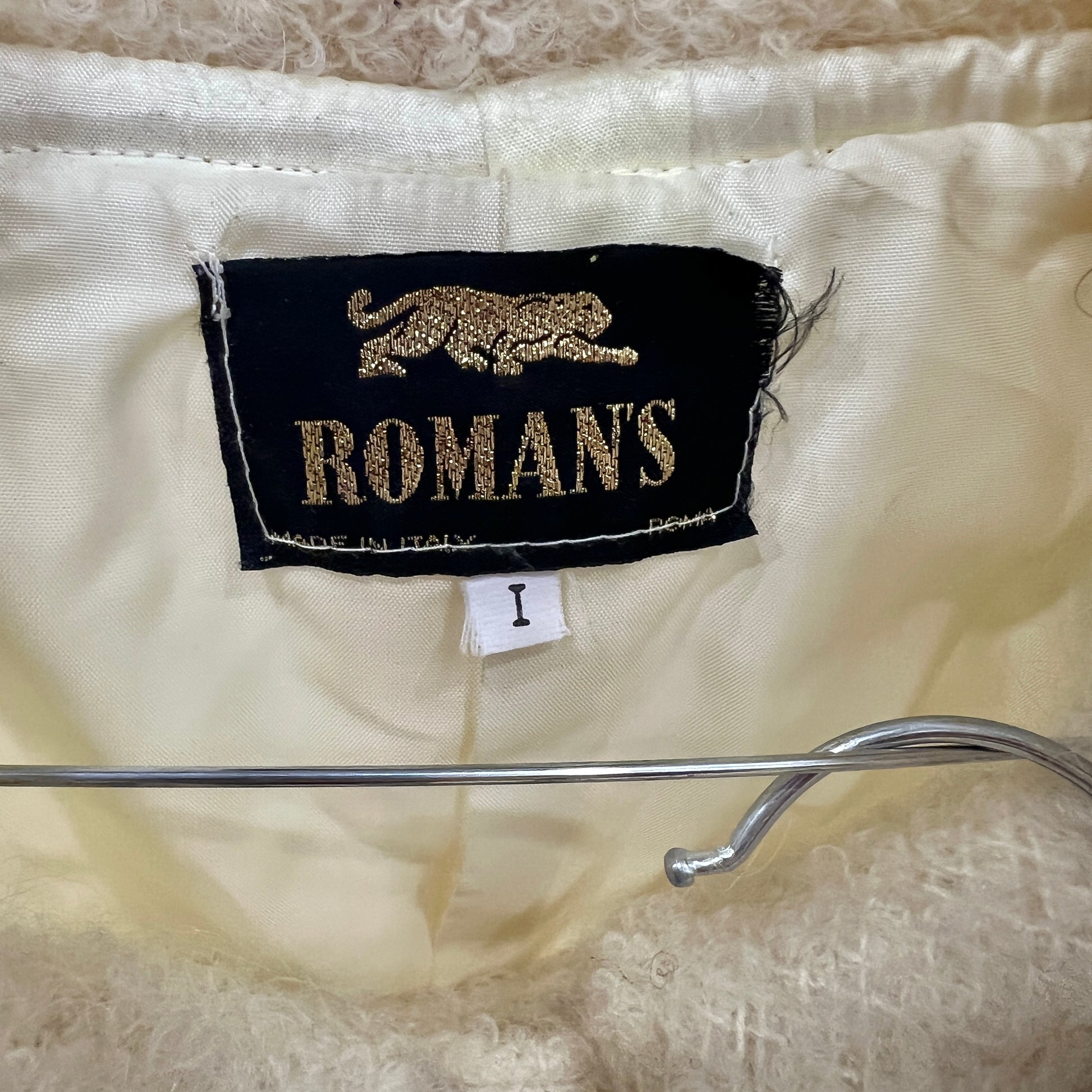 Label with 'ROMAN'S' branding on a textured fabric background