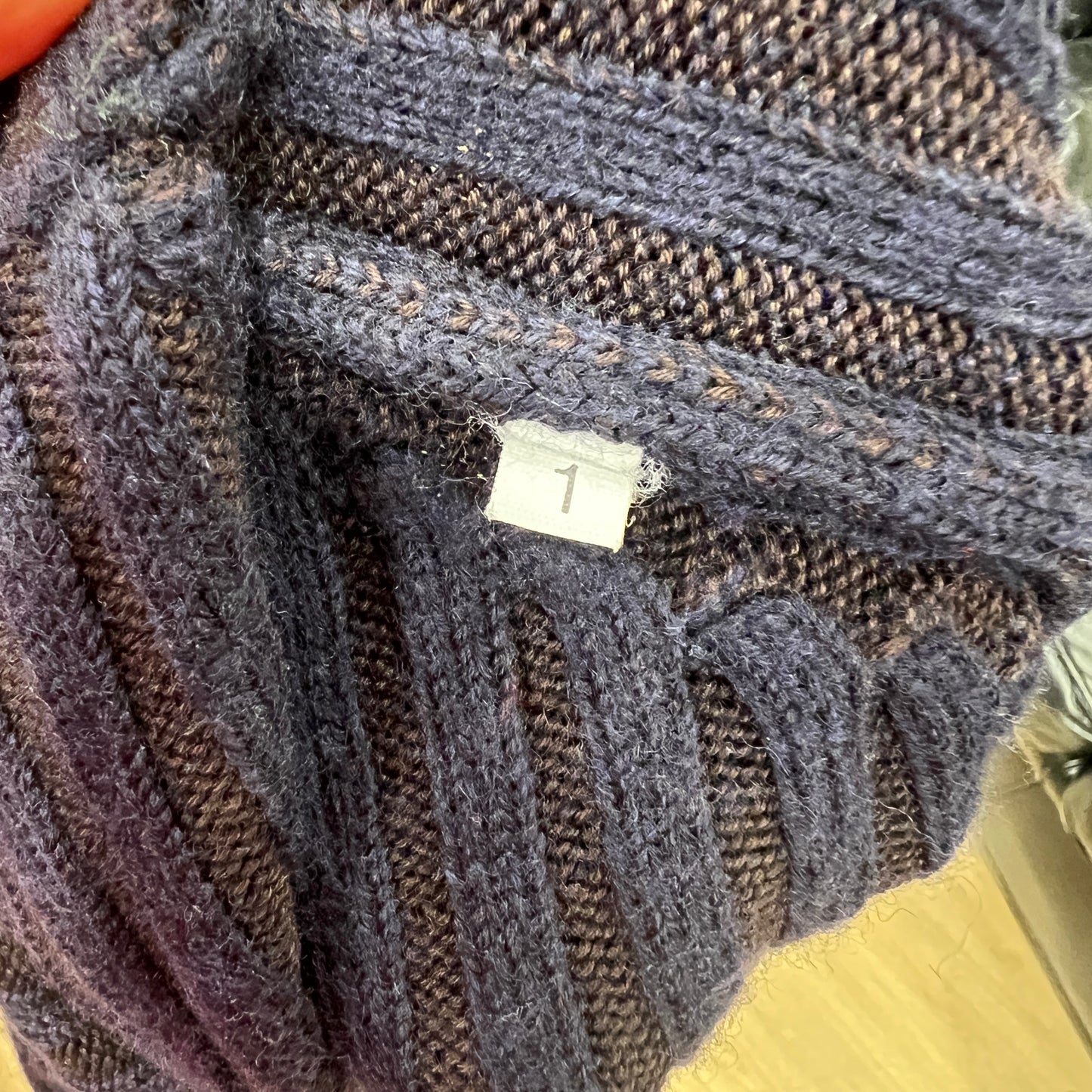 Close-up of a textured fabric with a visible tag, likely from a clothing item