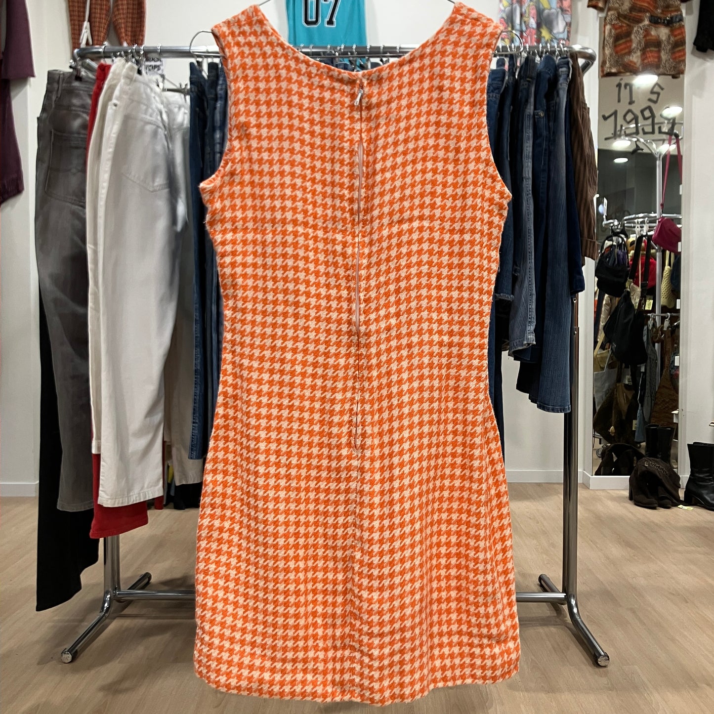 Orange checkered dress on a rack with clothing in the background