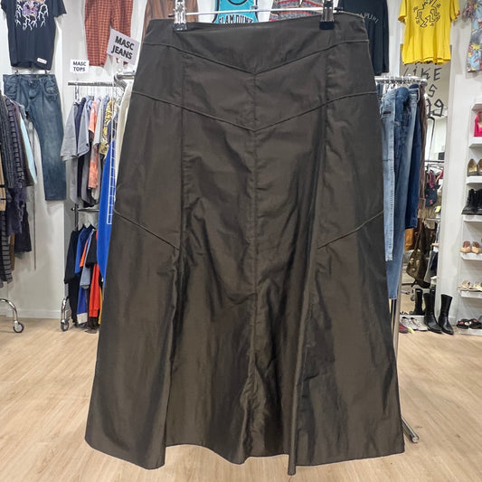 Dark skirt displayed in a clothing store with racks of clothes in the background