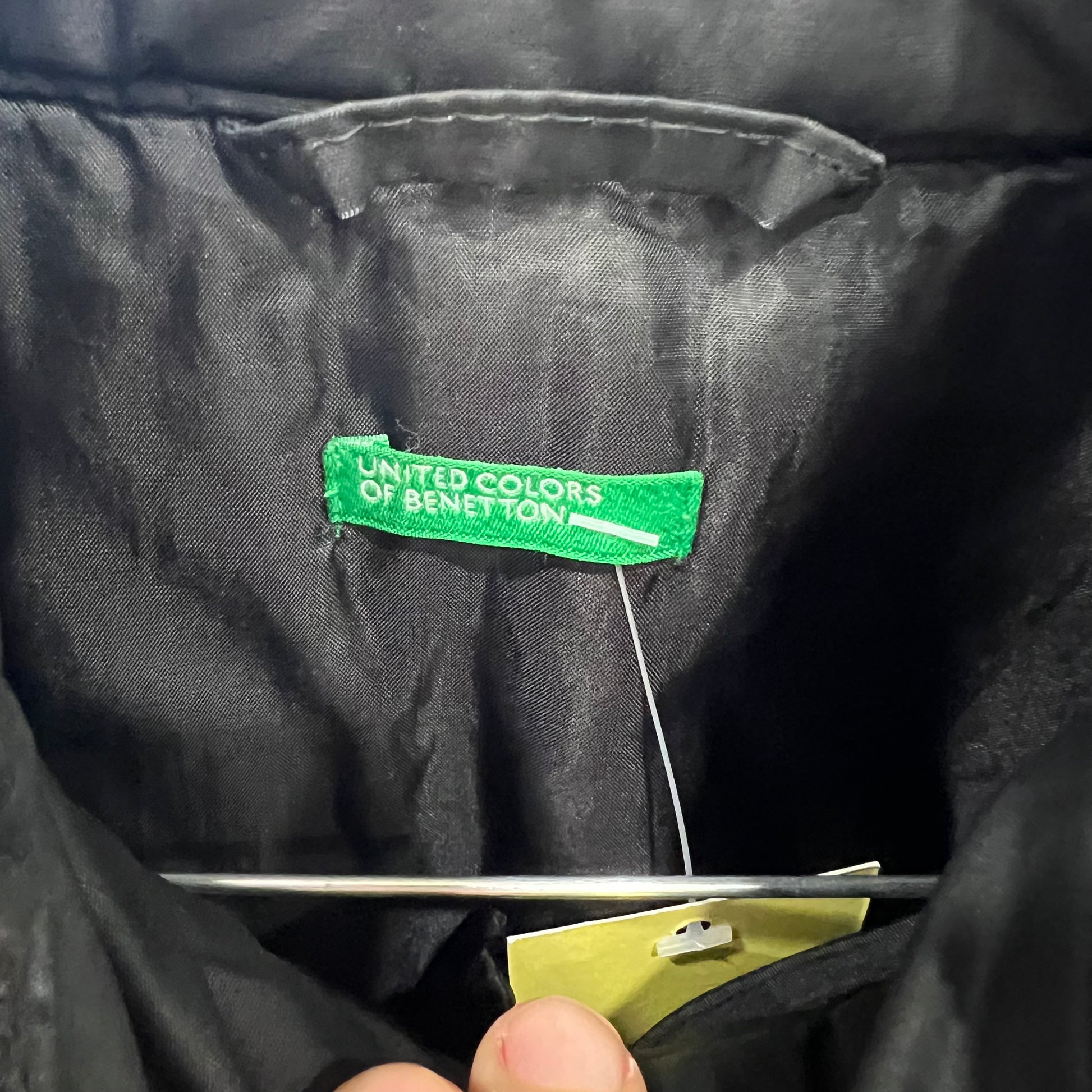 Close-up of a black jacket with a green 'United Colors of Benetton' label