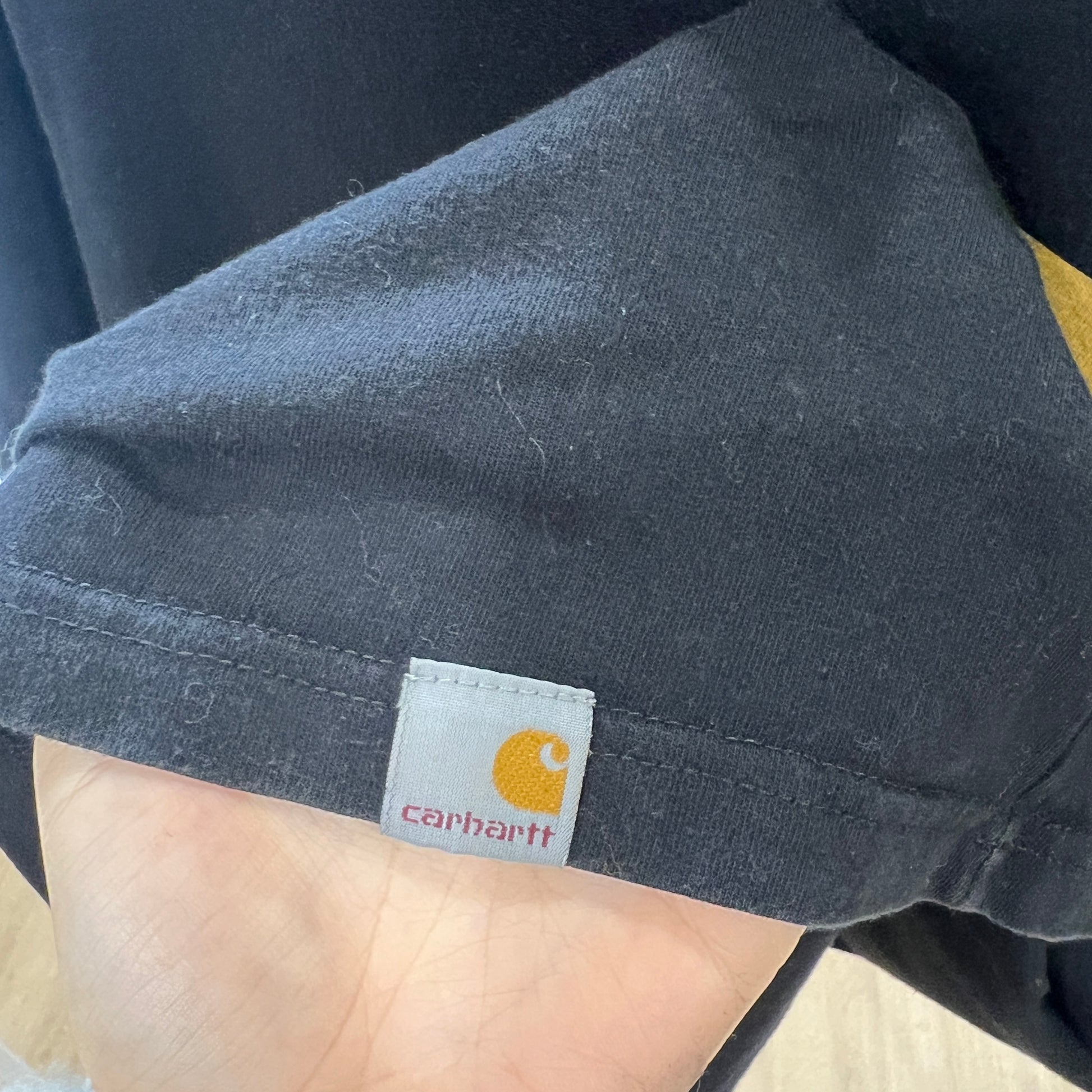 Close-up of a Carhartt label on a dark-colored shirt