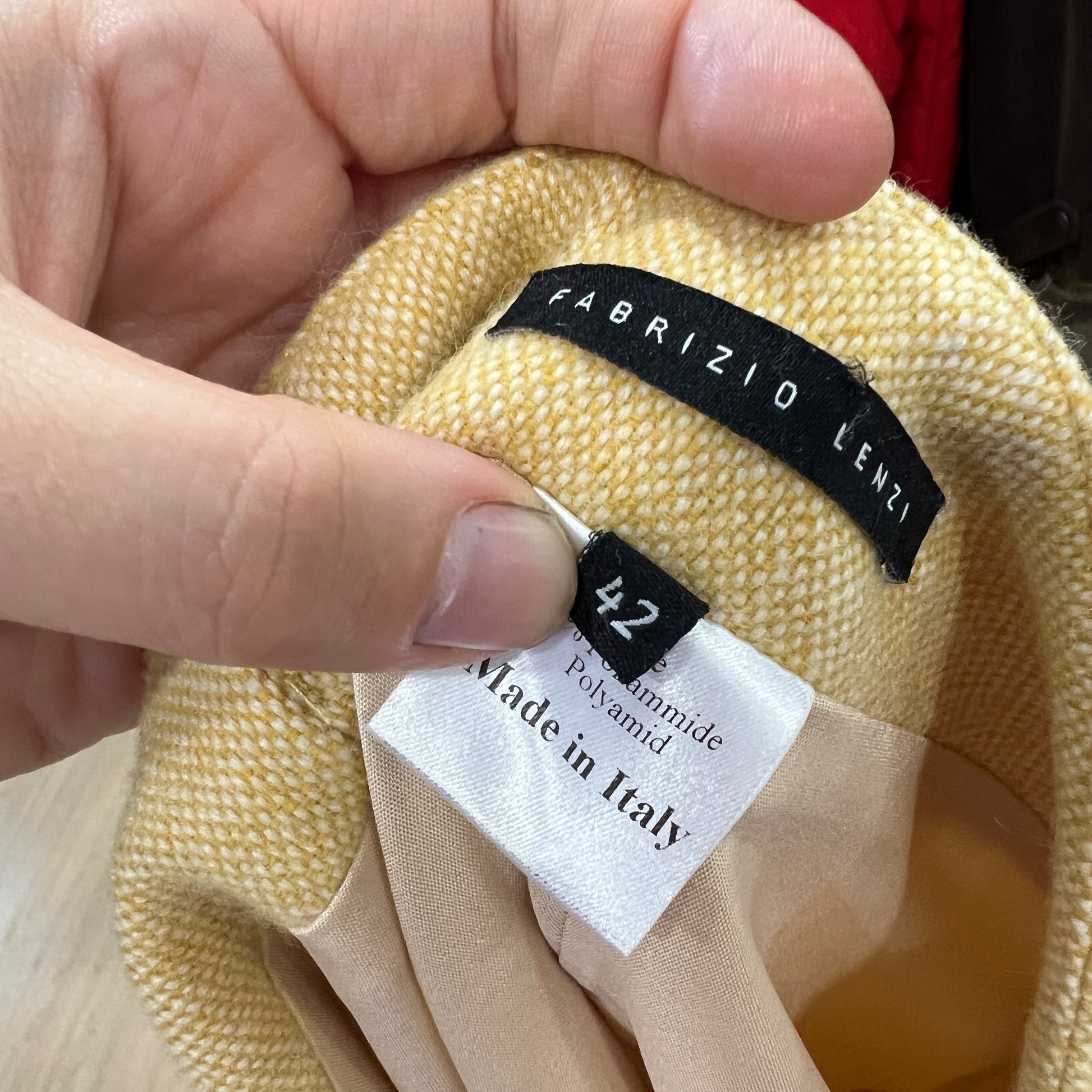 Close-up of a fabric tag with 'Fabrizio Lenzi' branding and product details