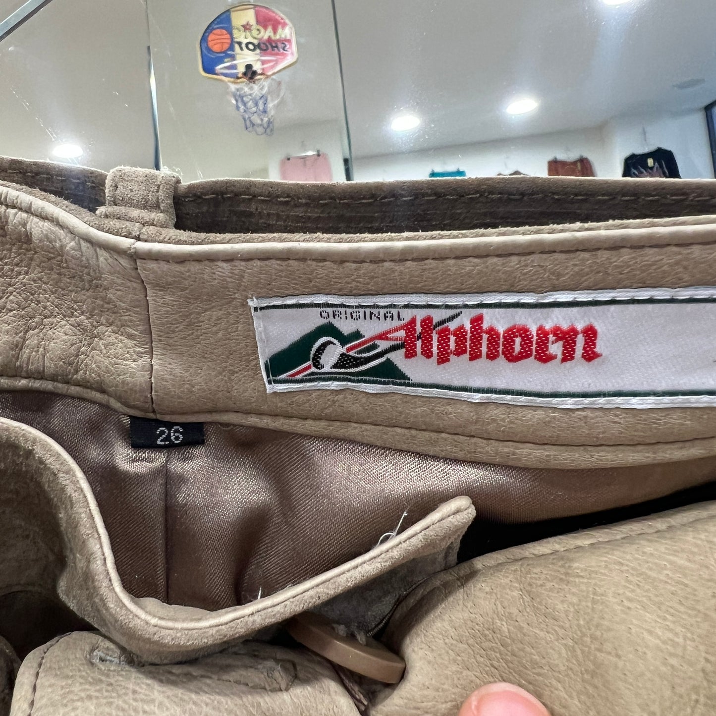 Close-up of a beige leather garment showing the interior label ‘Original Alphorn’ and size tag 26