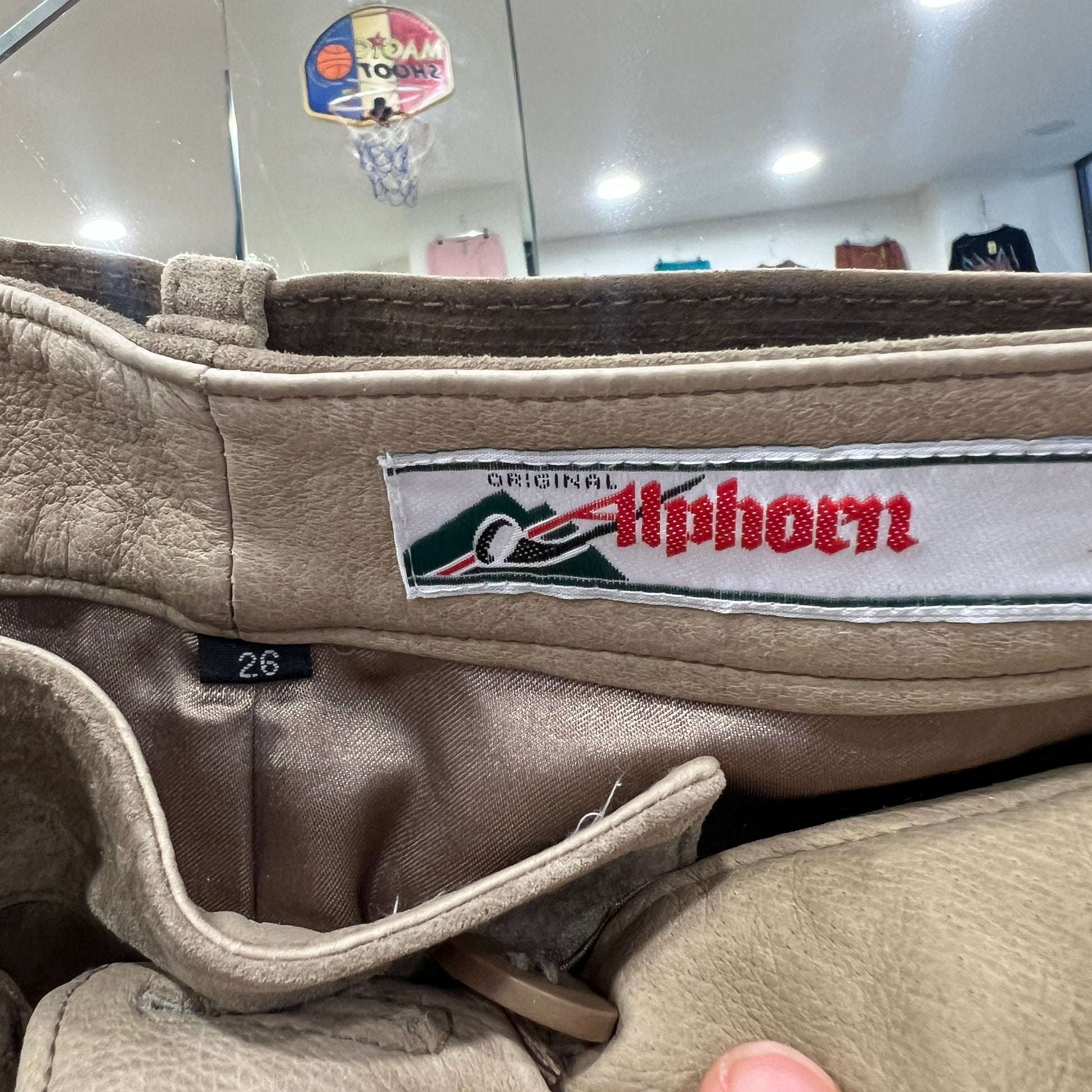 Close-up of a beige leather garment showing the interior label ‘Original Alphorn’ and size tag 26